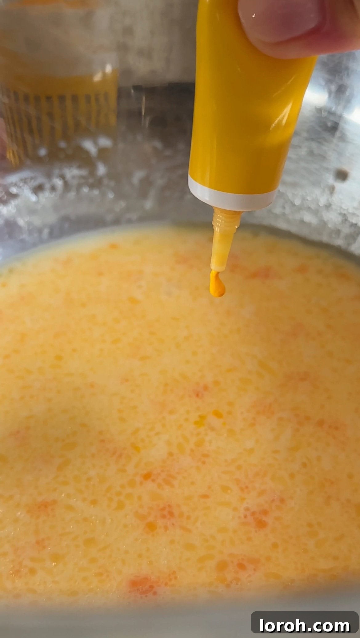 making batter for mango pancakes, showing yellow food coloring being added