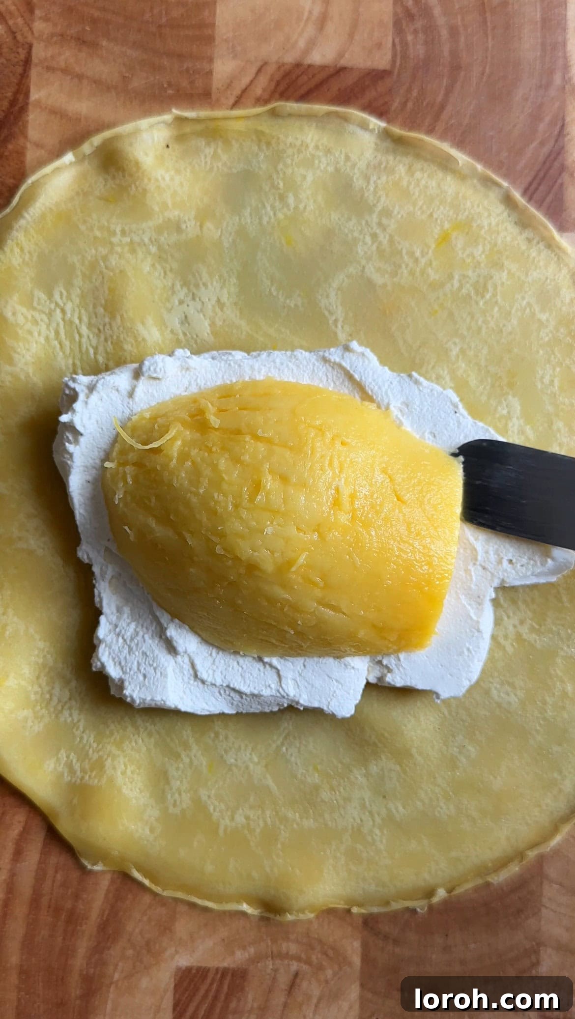 half a mango slice on whipped cream inside a pancake