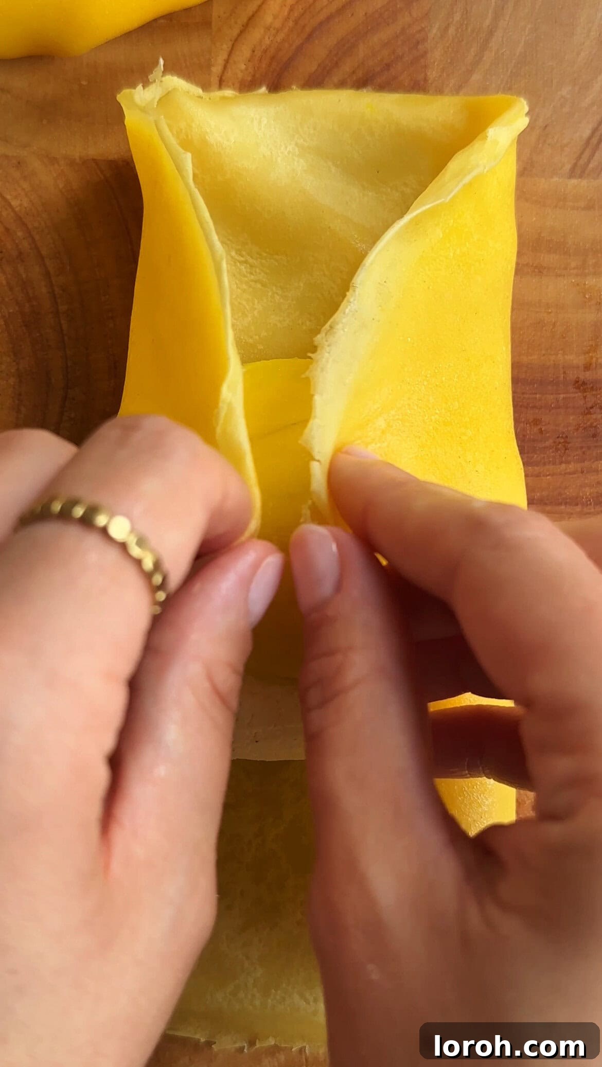 woman folding mango pancakes, showing the initial side folds