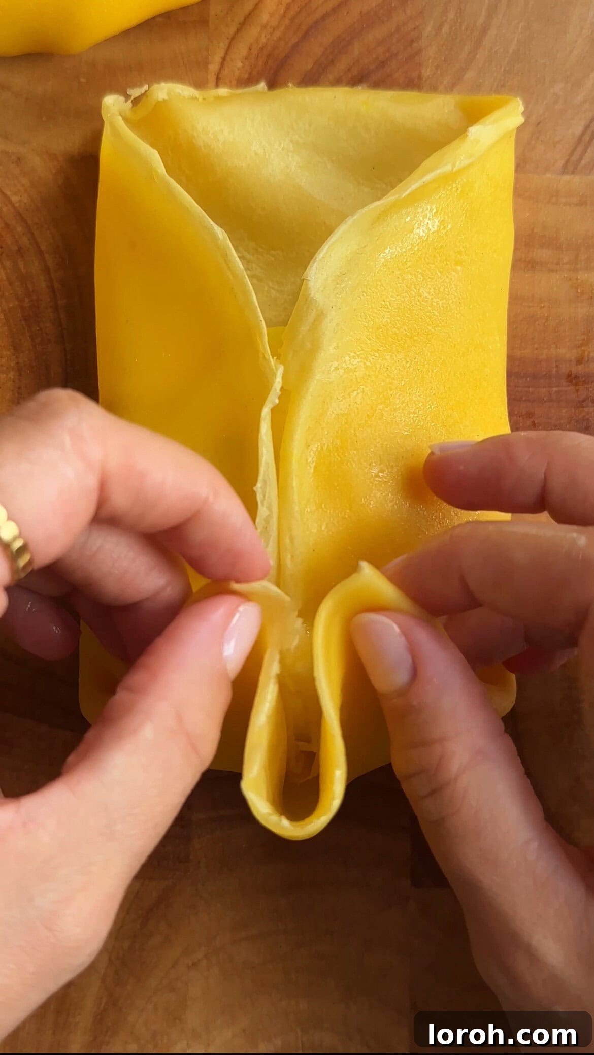 woman folding mango pancakes, showing the final top and bottom folds