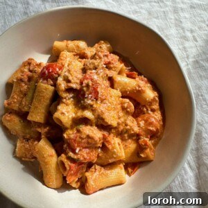 A perfectly portioned bowl of creamy tuna pasta with fresh herbs and a drizzle of olive oil.