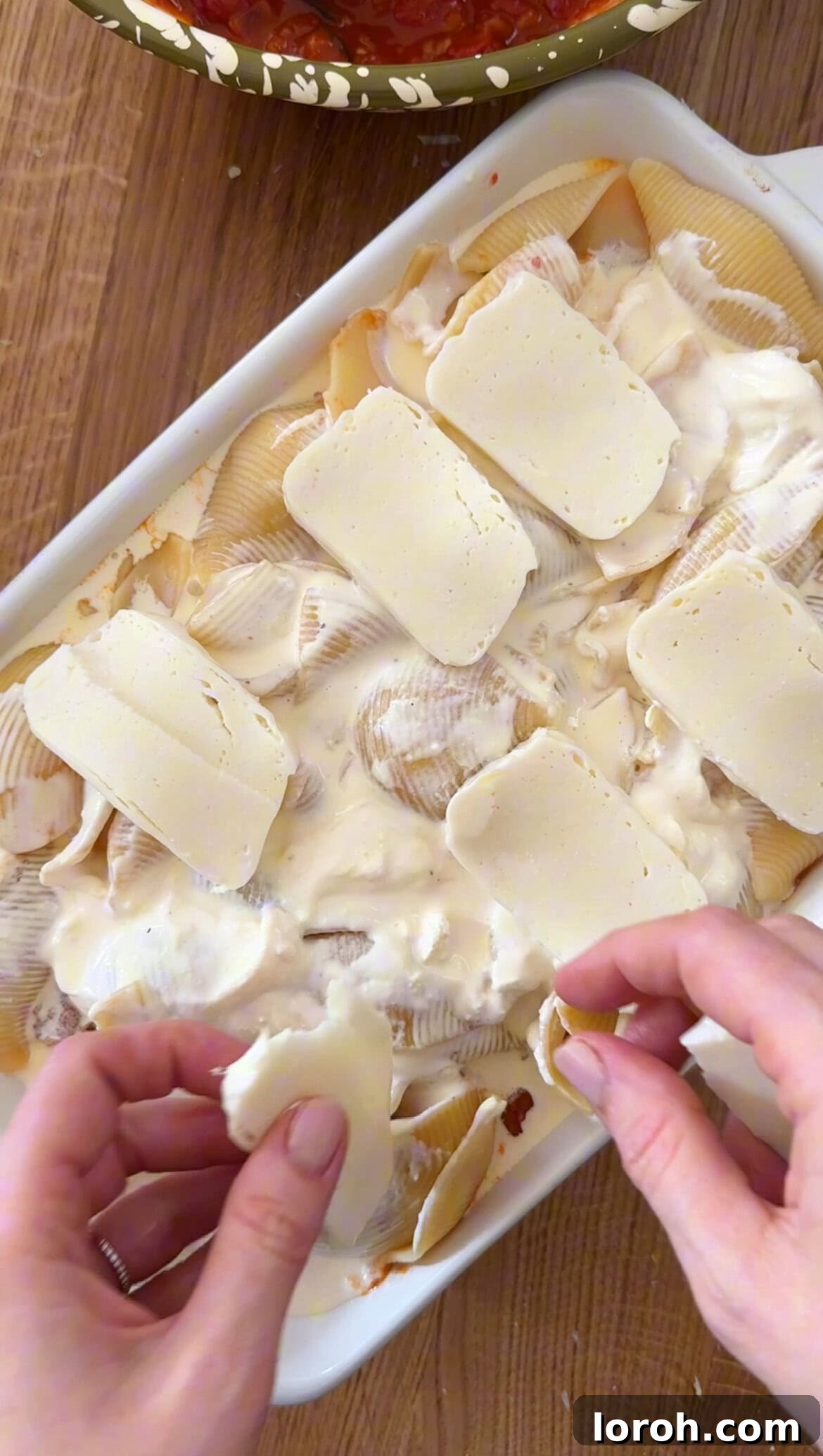 Final layer of mozzarella and Parmesan cheese on top of the aubergine pasta bake before baking.