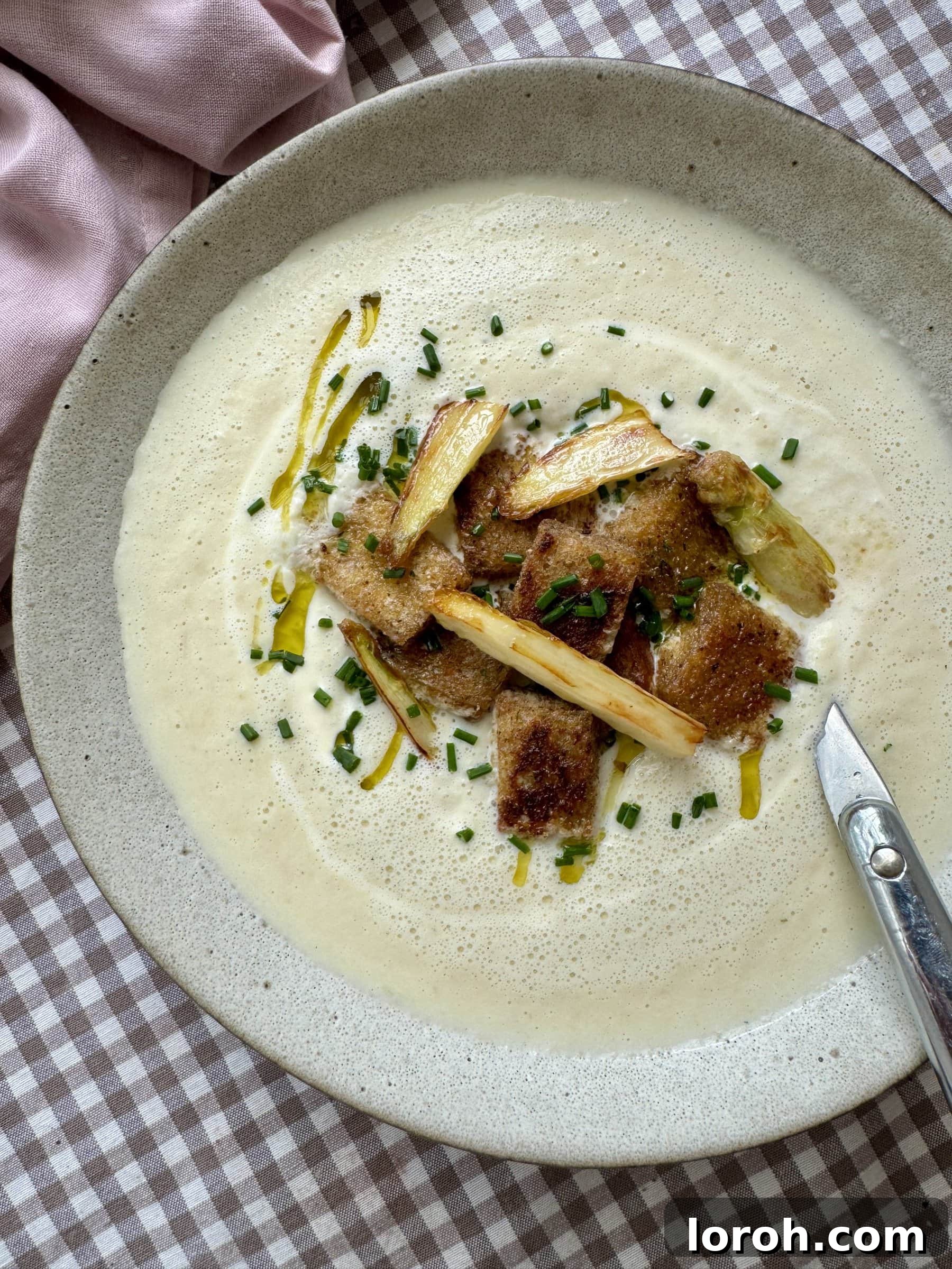 spargel, white asparagus soup in a white bowl with toppings