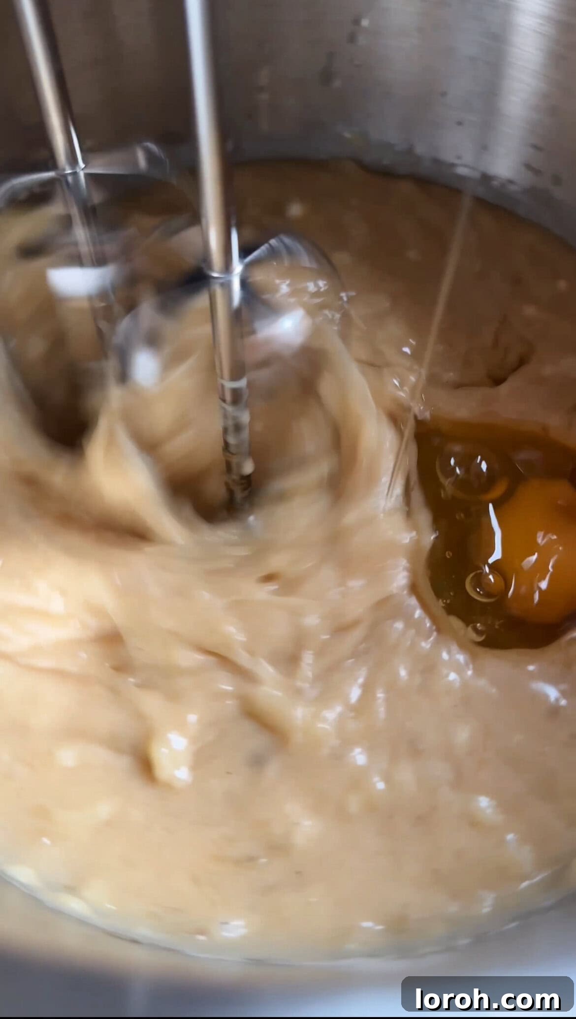 Cracking and whisking eggs into the banana bread wet batter mixture.