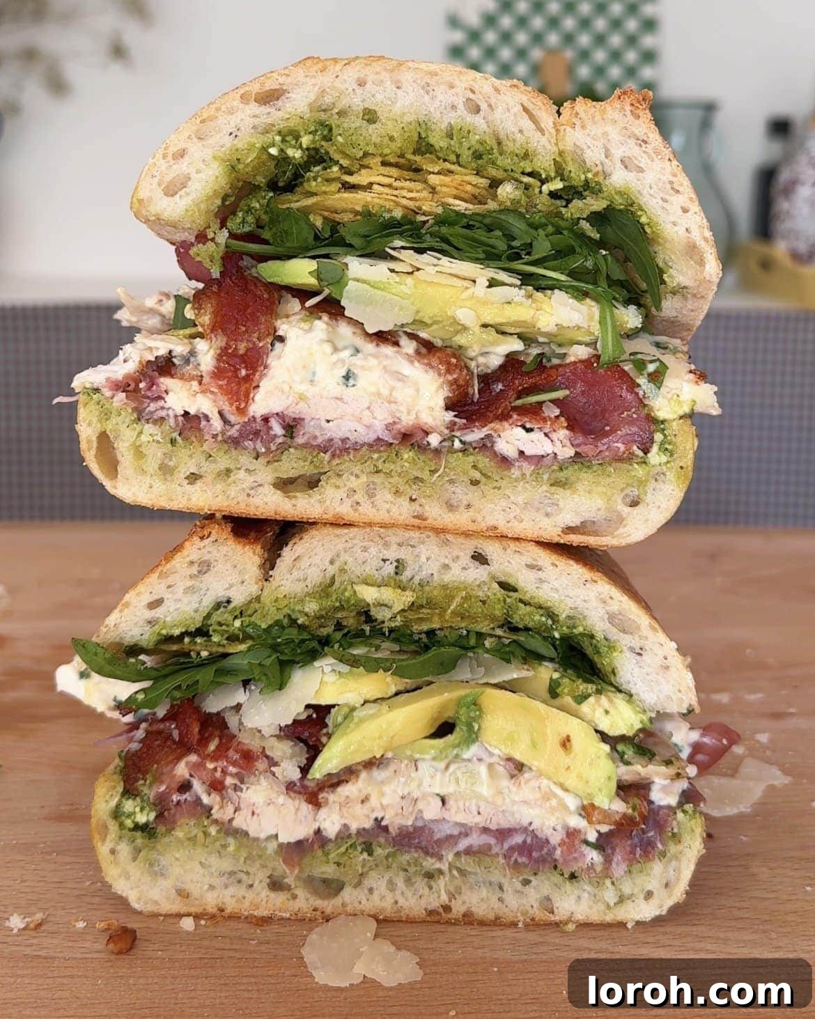 Stacked gourmet chicken mayonnaise sandwiches on a rustic wooden board, showcasing layers of delicious fillings.