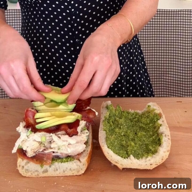 Adding slices of ripe avocado on top of the chicken mayonnaise mixture.