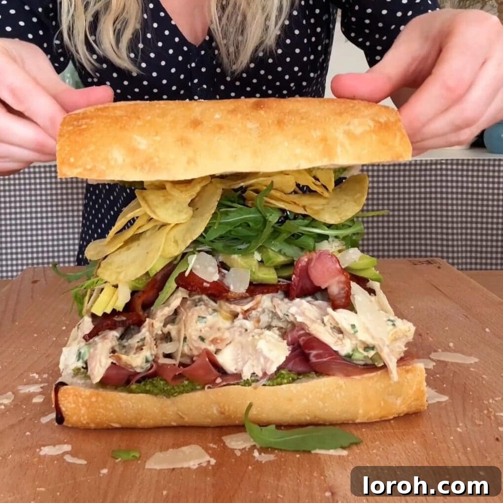 Placing the top piece of hollowed-out bread onto the filled sandwich.