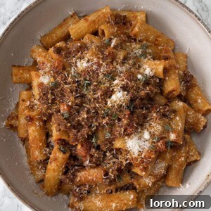 Deliciously Quick Bolognese Sauce with Rigatoni in a beige bowl, photographed from above.