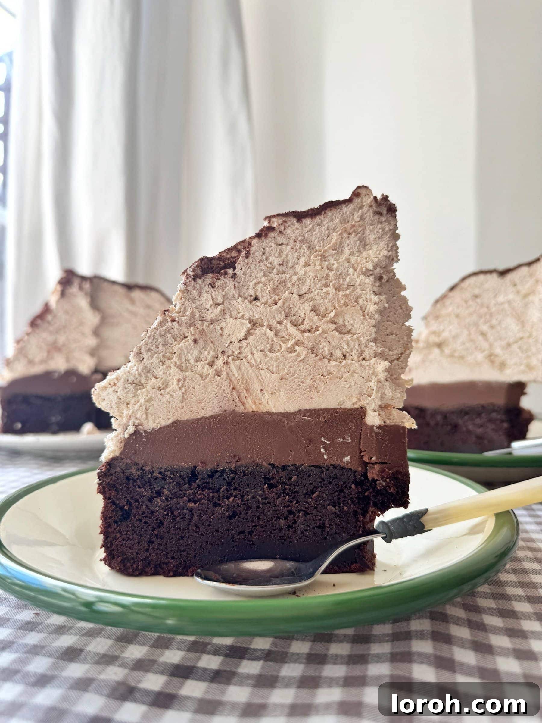 Decadent Chocolate Mud Cake with Malted Cream 2 A sumptuous slice of chocolate mud cake, adorned with fluffy malted whipped cream, resting on an elegant green plate.