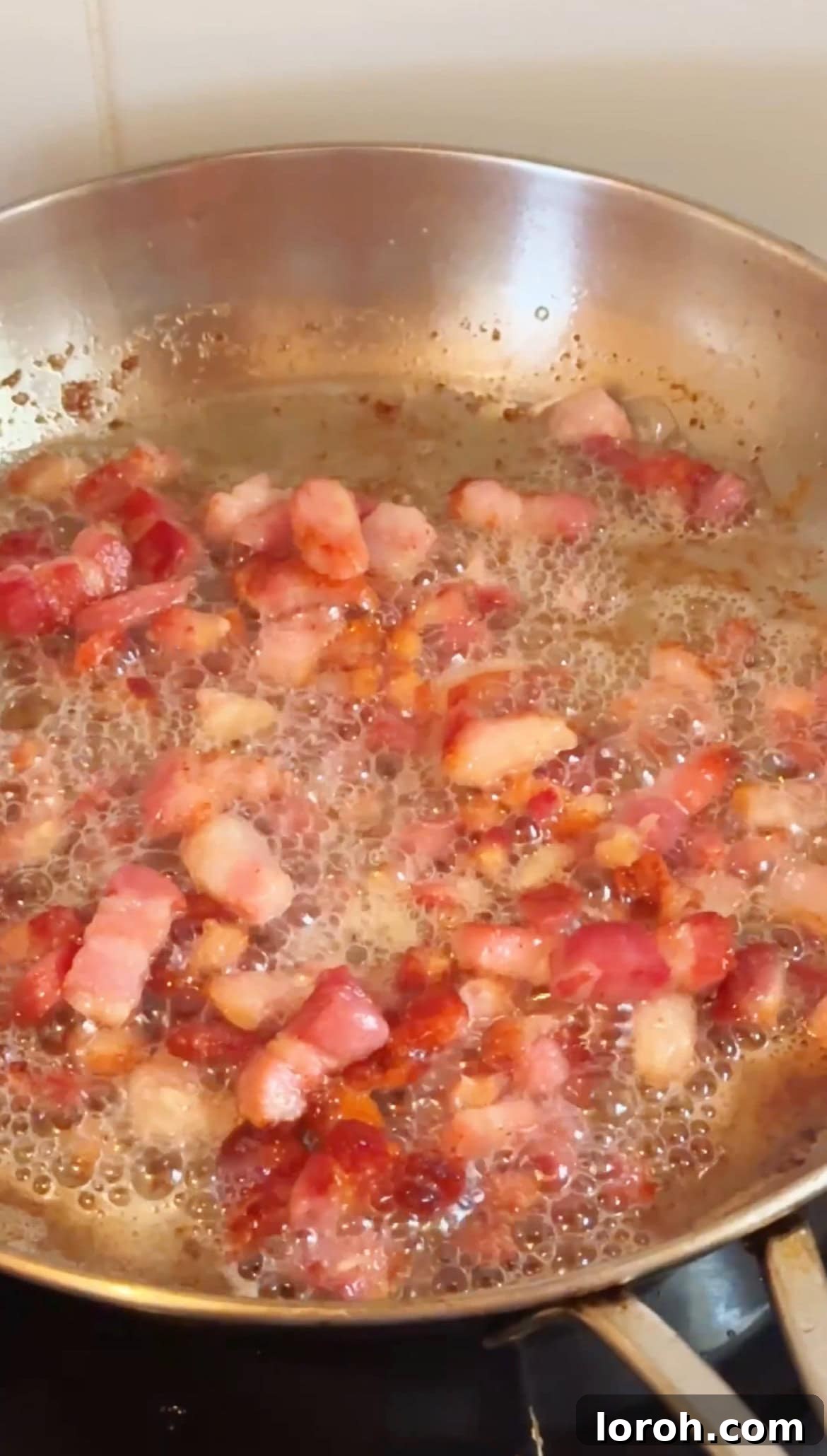 Frying pancetta until crispy and golden.