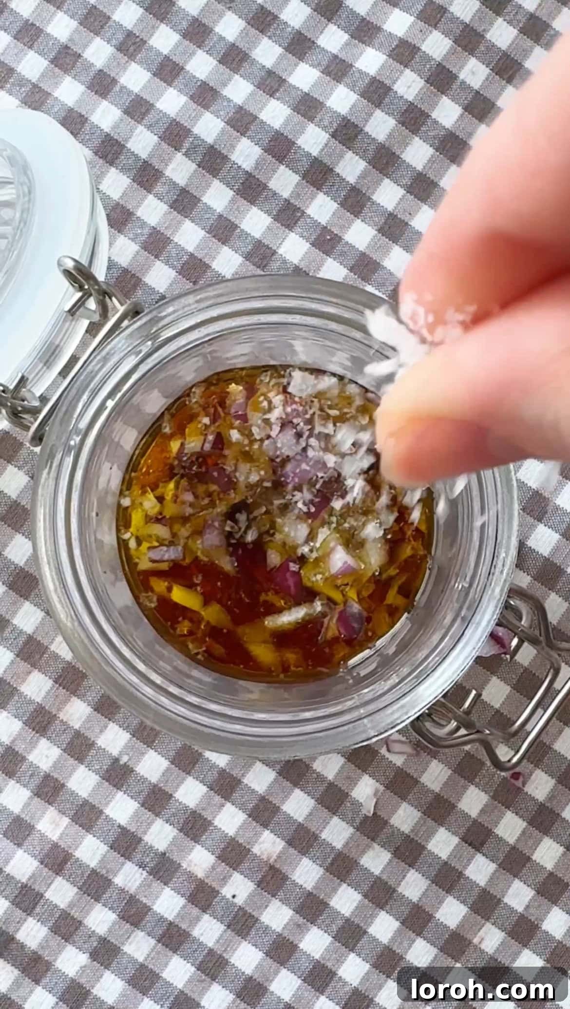 Mixing ingredients for the vinaigrette dressing in a jam jar.