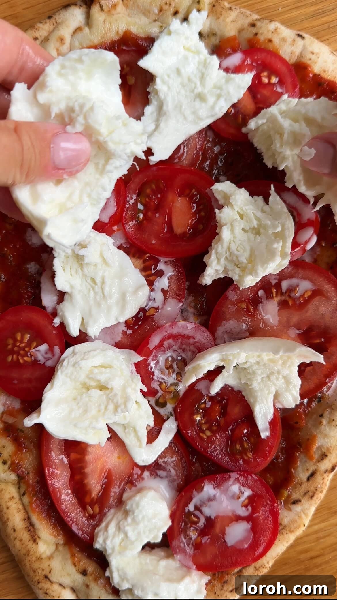 Margherita Flatbread Pizza 8 Topping the flatbread pizza with torn fresh mozzarella and cherry tomatoes before baking.
