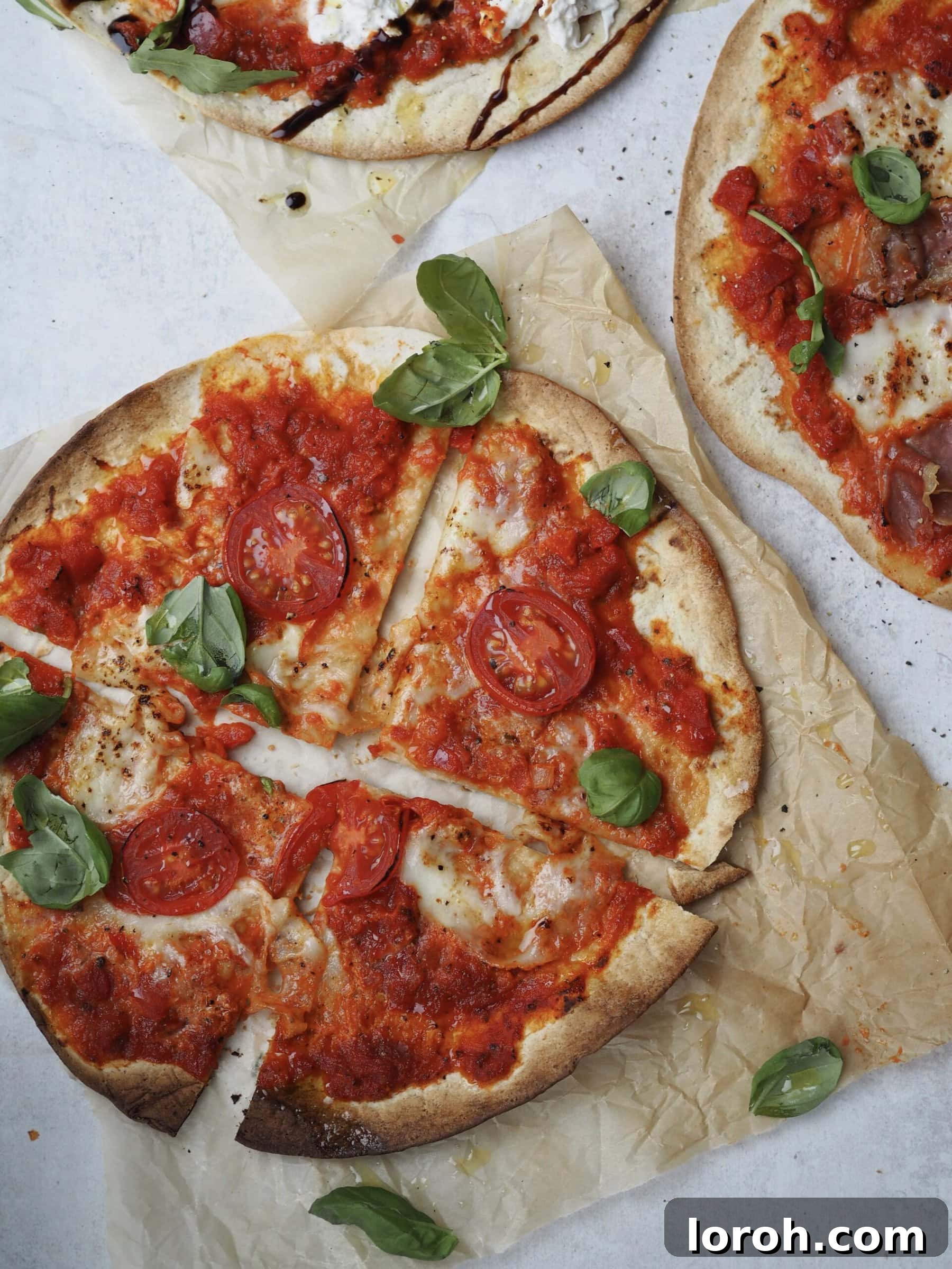 Margherita Flatbread Pizza 10 Finished Flatbread Margherita Pizza, precisely cut into four equal slices, resting on greaseproof paper.