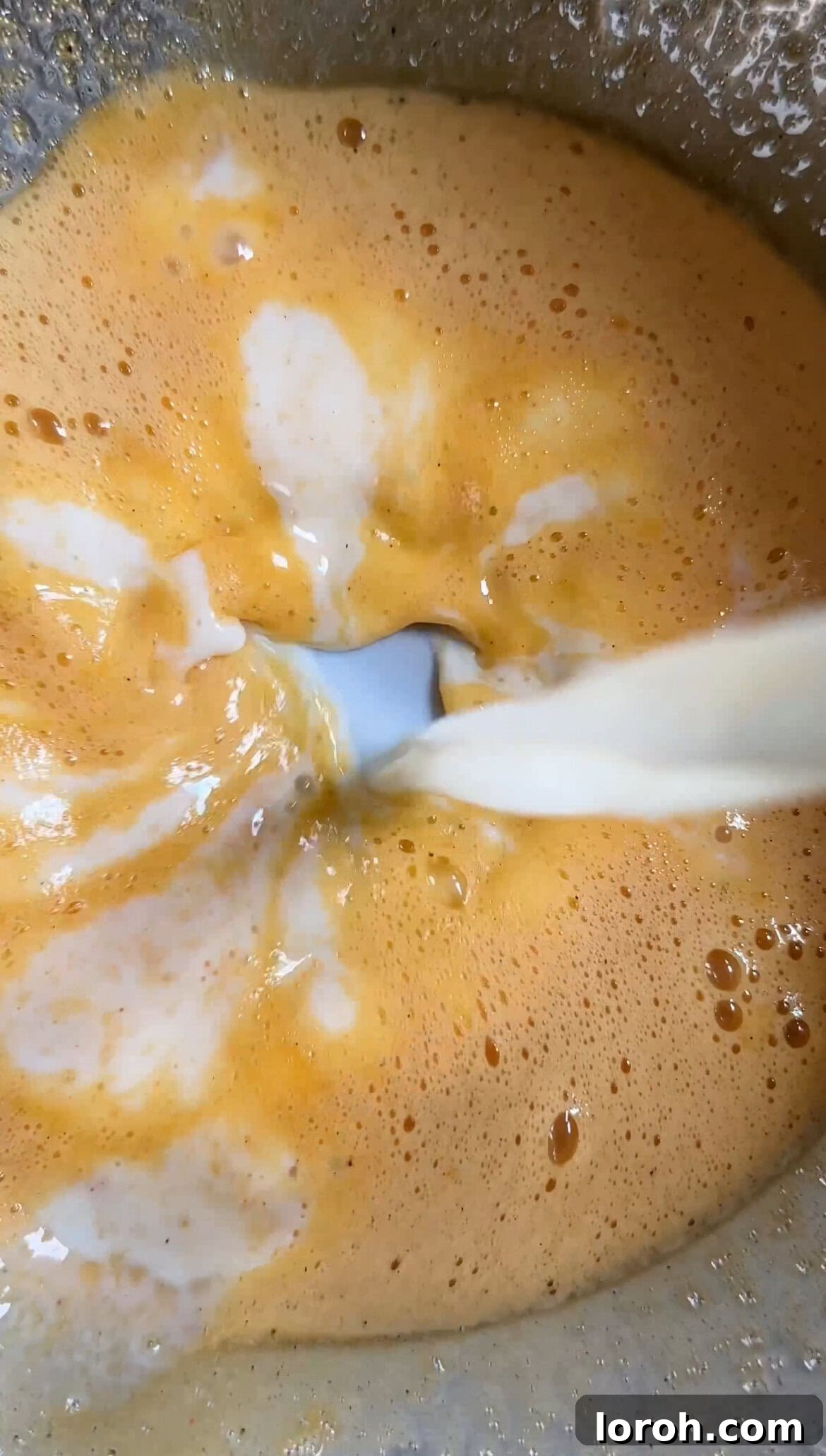 Mixing egg yolks, sugar, and vanilla extract until pale and thickened for the cake batter.