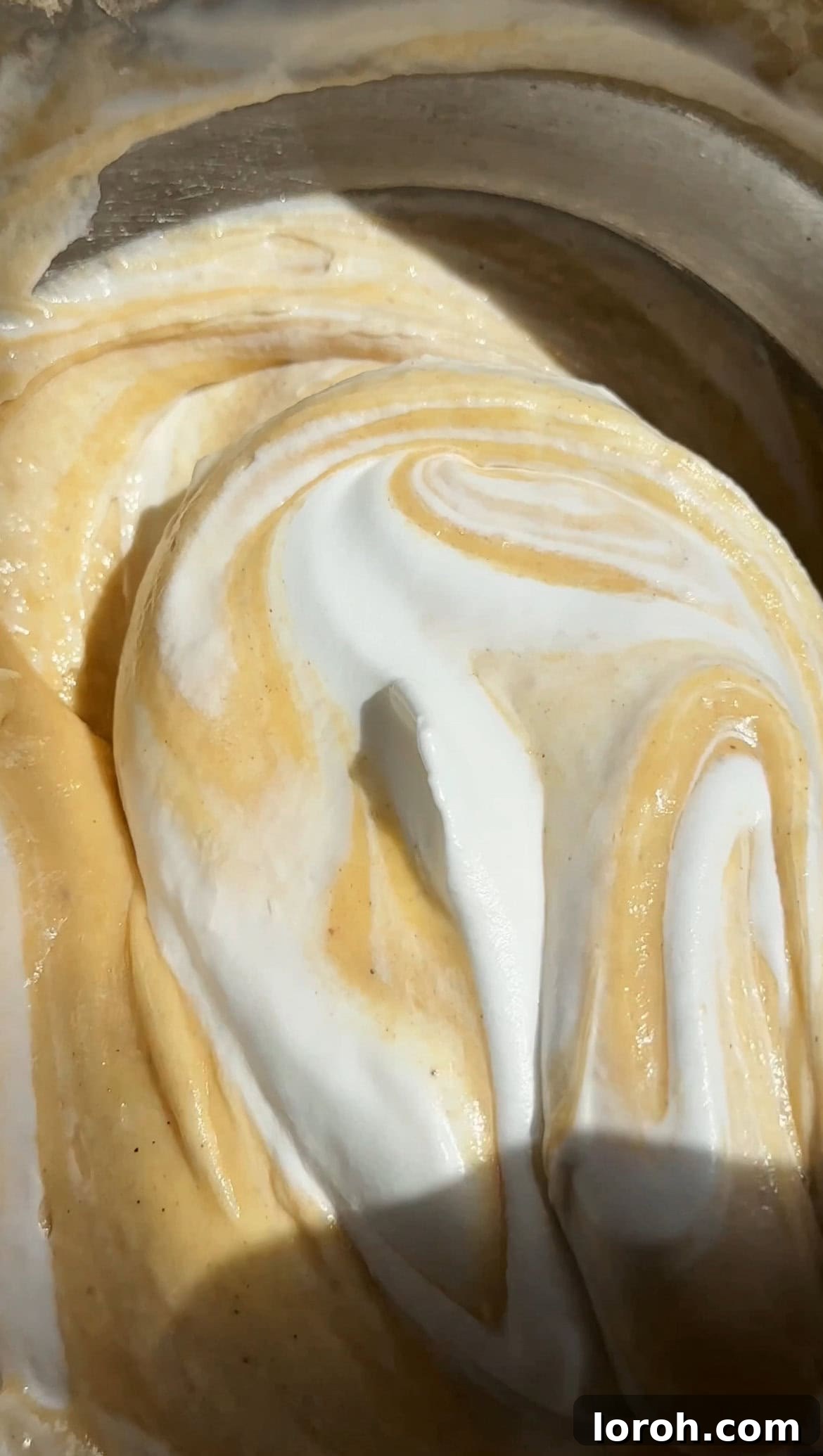 Gently folding the meringue into the cake batter to maintain airiness.