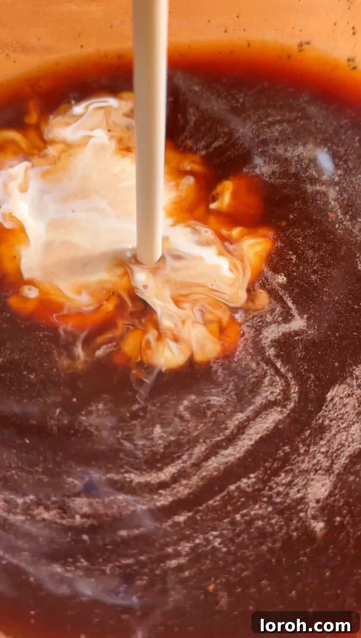Whisking coffee, condensed milk, cream, and liqueur to create the coffee soak mixture.