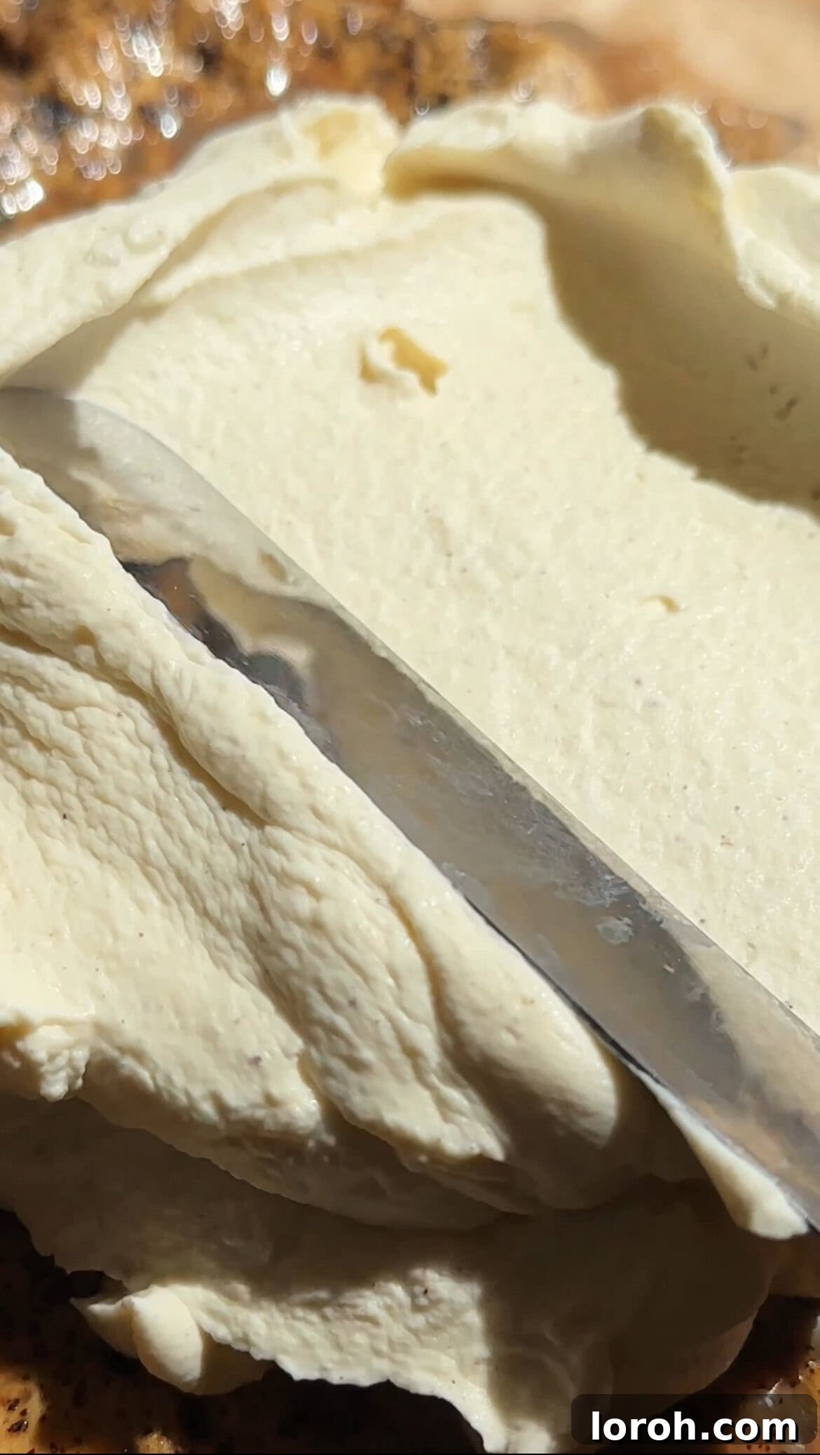 Spreading the smooth mascarpone whipped cream topping evenly over the chilled tres leches cake.