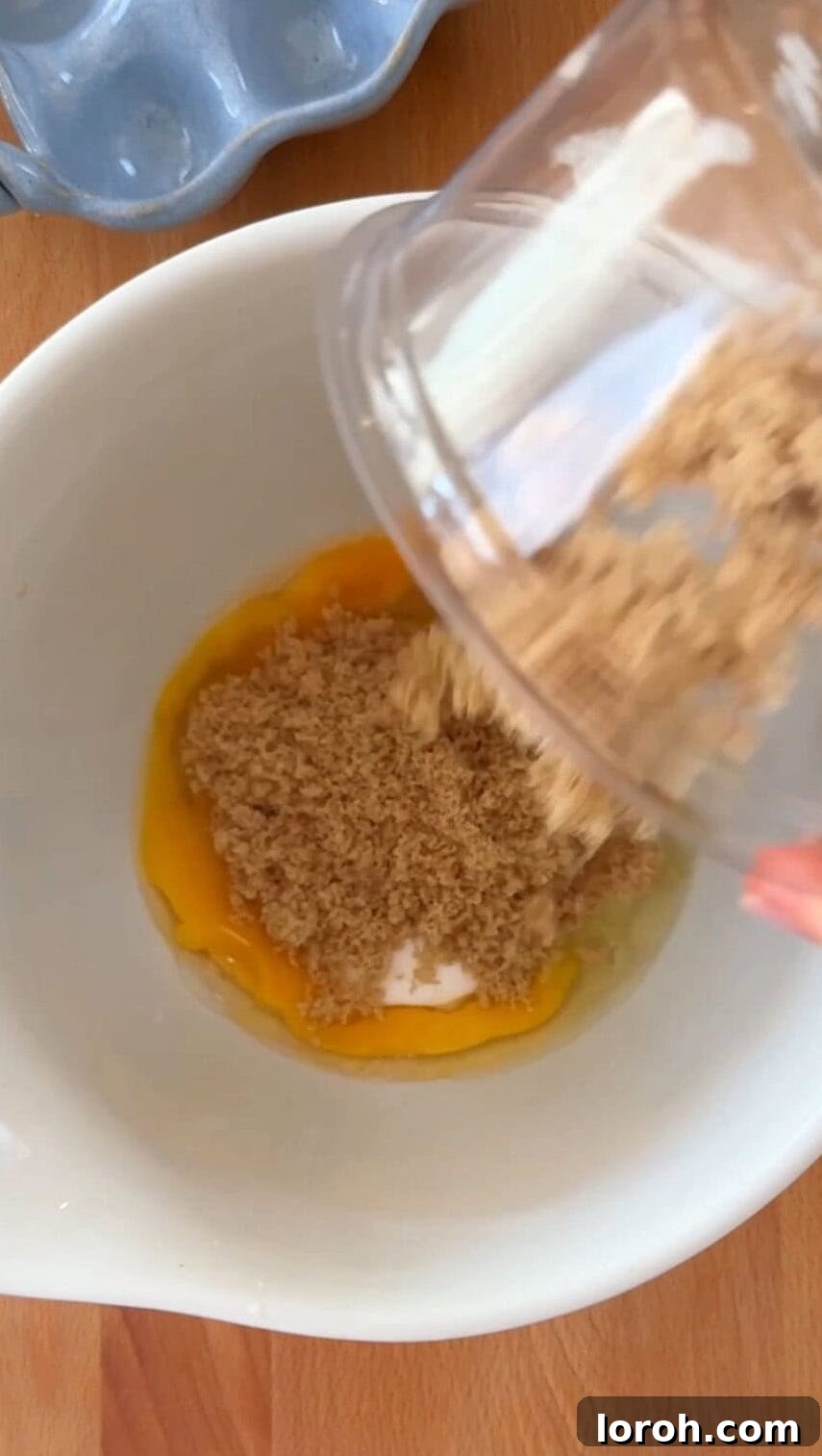 Brownie Nibbles 6 Step two: Eggs and sugars being vigorously beaten in a large mixing bowl with an electric whisk until pale, thick, and greatly increased in volume.
