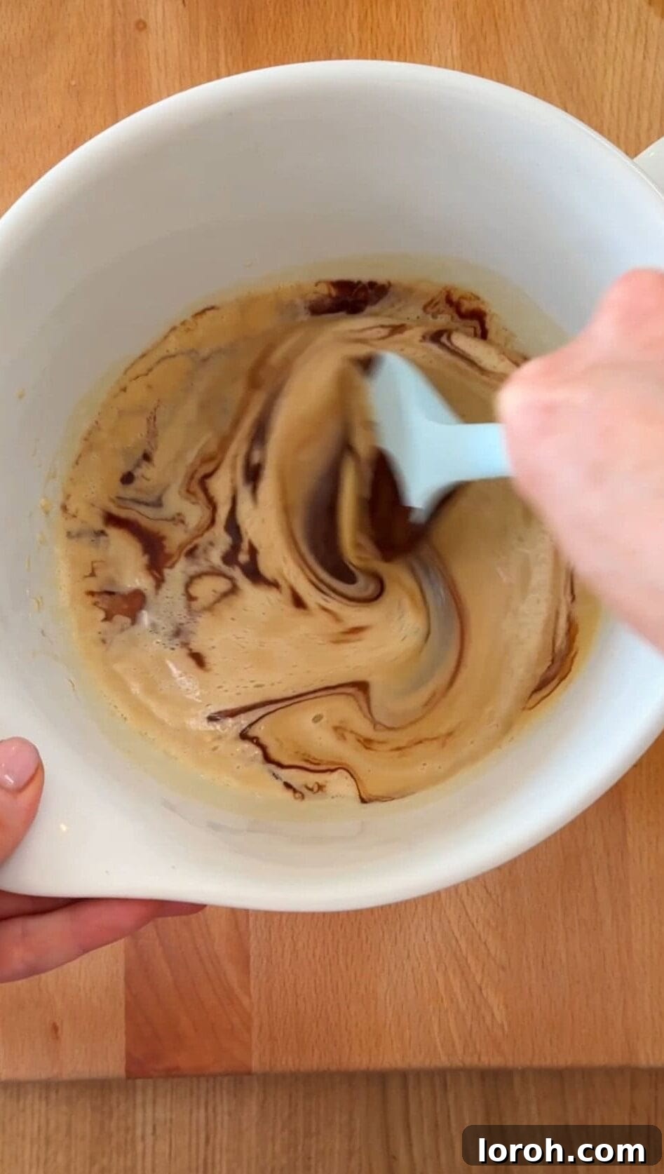 Brownie Nibbles 7 Step three: The melted chocolate-butter mixture and vanilla extract being gently folded into the whisked egg and sugar mixture.