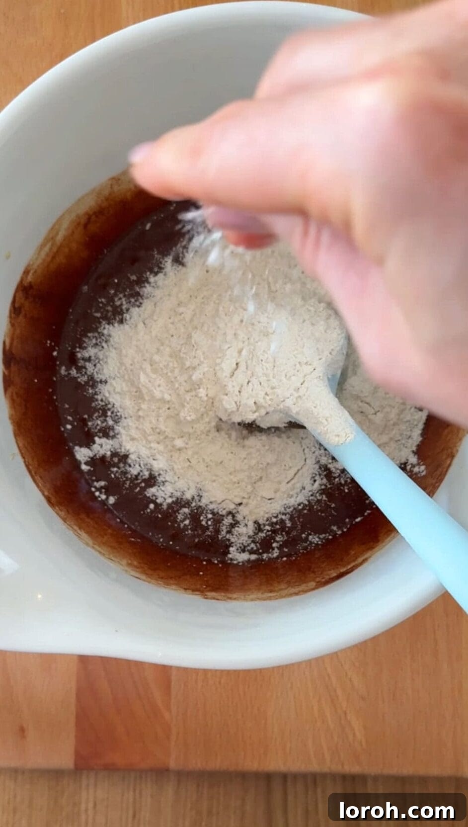 Brownie Nibbles 8 Step four: Flour and salt being sifted into the brownie batter, followed by chopped chocolate, then gently folded until smooth and evenly distributed.
