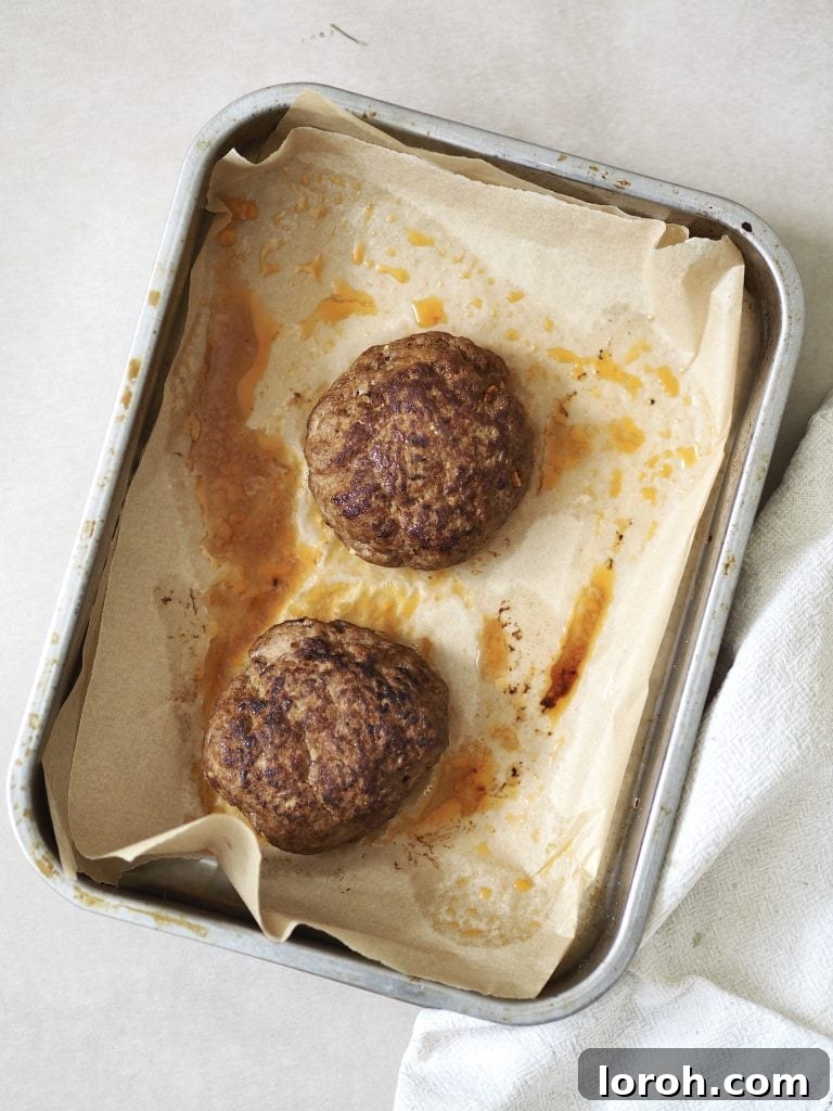 Lamb Burgers: A Fresh Mediterranean-Italian Blend 5 Two cooked lamb burgers on a lined oven tray.
