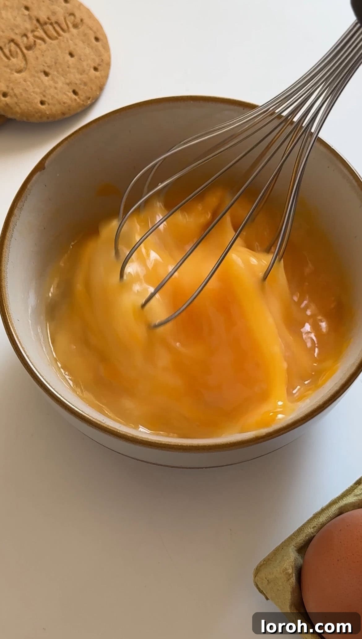 Golden Torched Cheesecake 6 Lightly beaten eggs in a bowl, ready to be added to the cheesecake mixture.