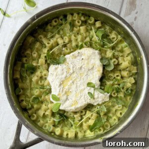 One pan pasta and peas in a pan with burrata, ready to be served.