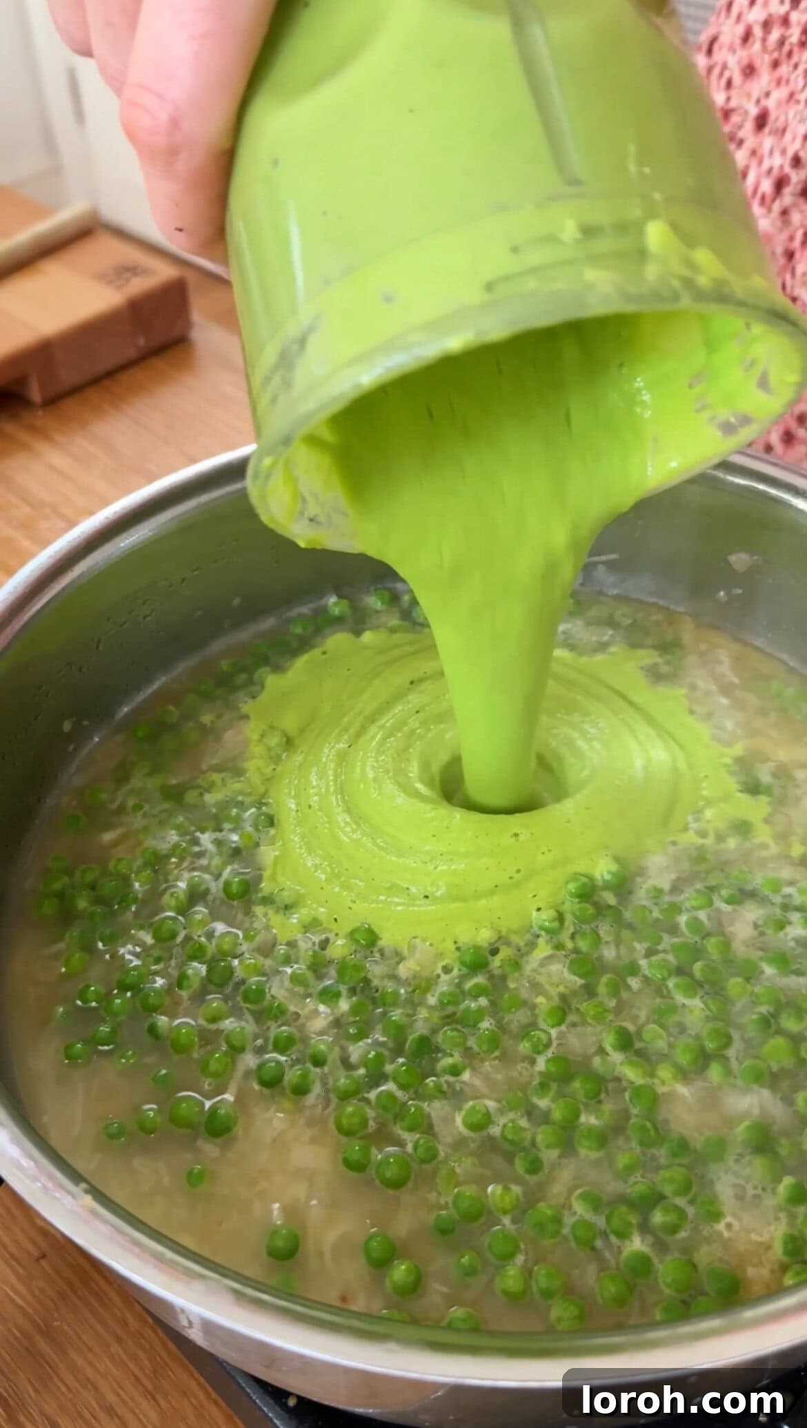 Pouring the blended pea mixture back into the pan with more hot water.