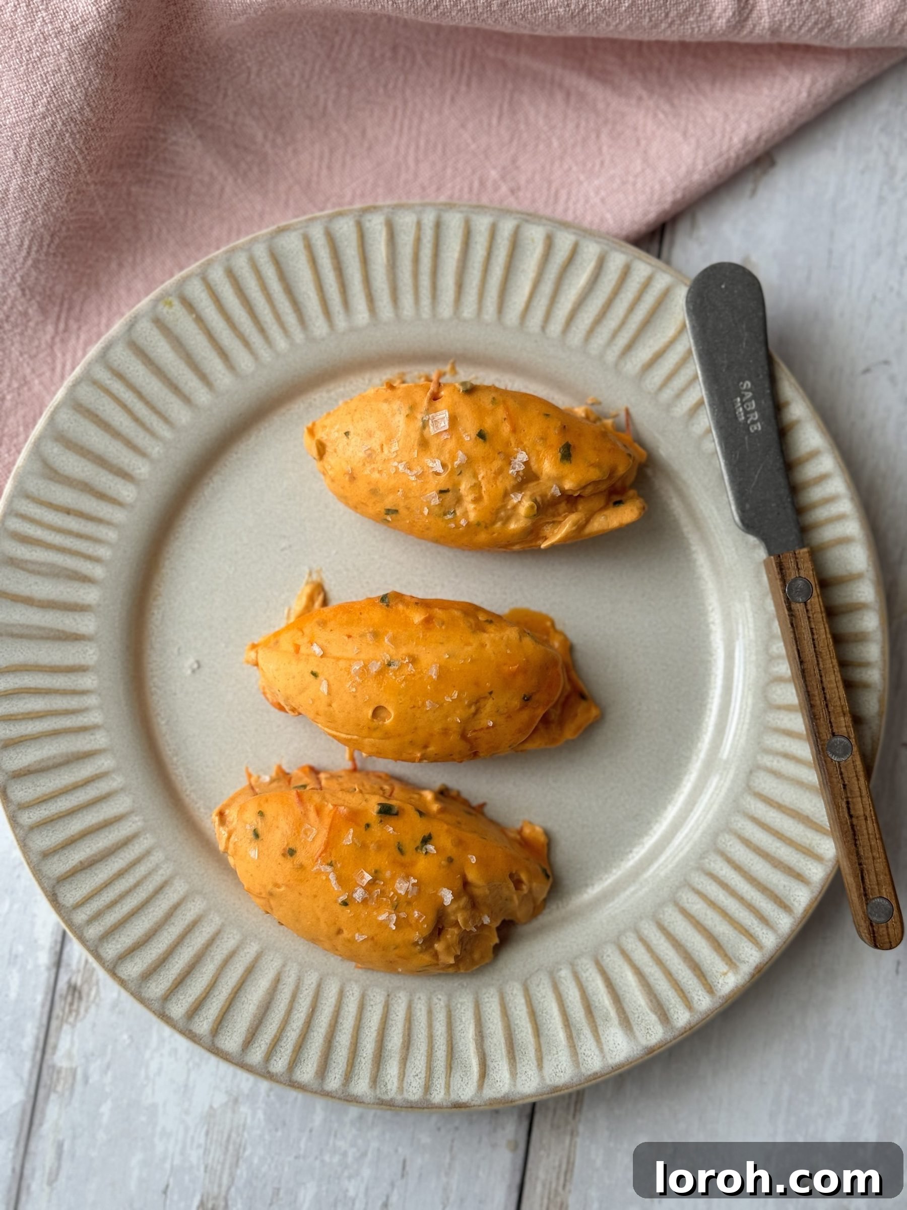 Tomato Butter: The Secret to Everything Delicious 2 Delicate quenelles of vibrant red roasted tomato butter, artfully arranged on a sleek grey plate.