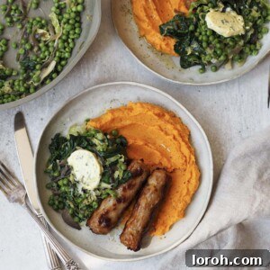 Grey plates of sweet potato mash, sausages and greens topped with a disc of garlic butter.
