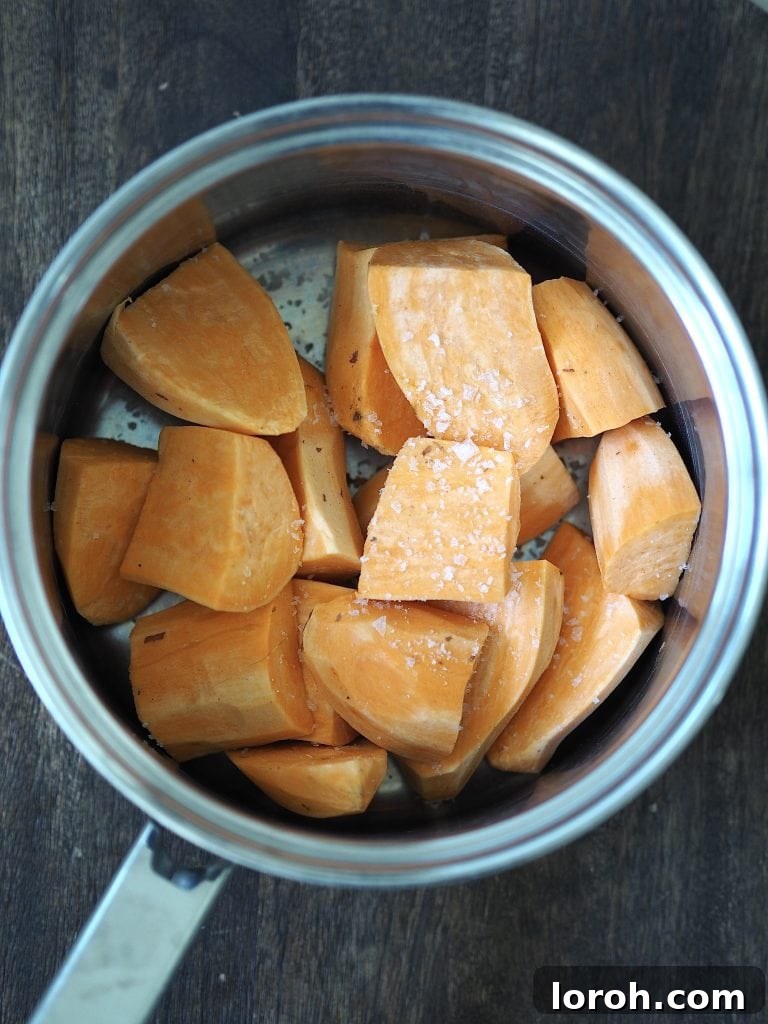 Diced sweet potatoes in a saucepan with flaky sea salt.
