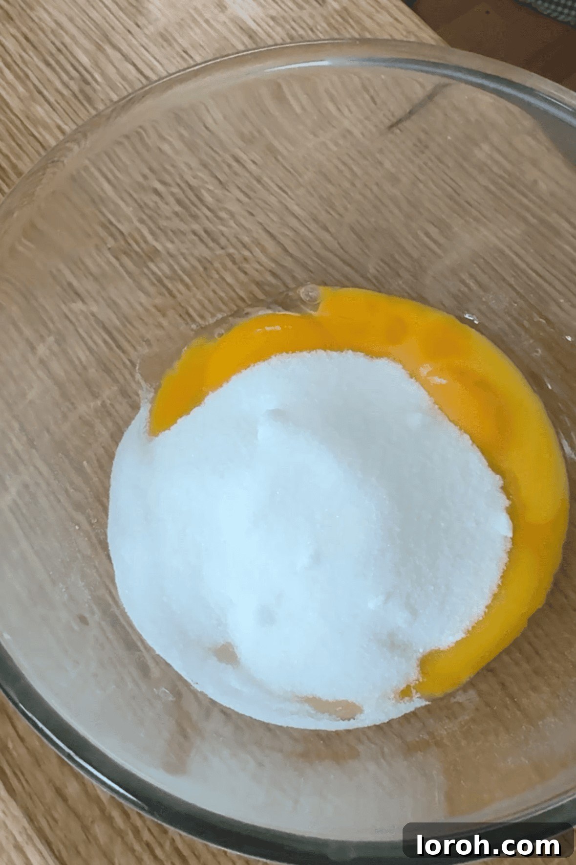 Whisking caster sugar and egg yolks together until the mixture becomes thick and pale yellow.