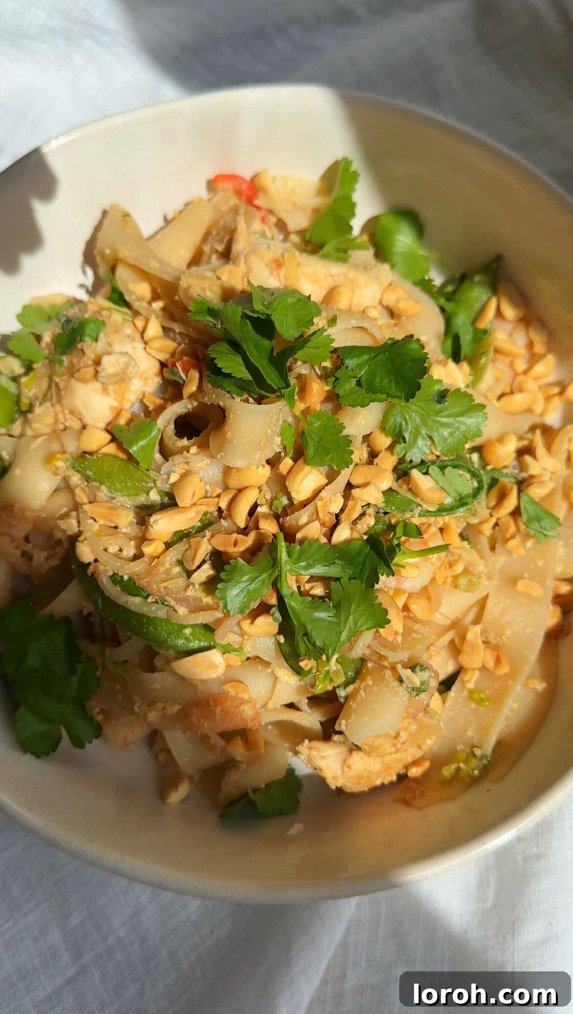 Plating up freshly cooked Wagamama Pad Thai into a serving bowl.