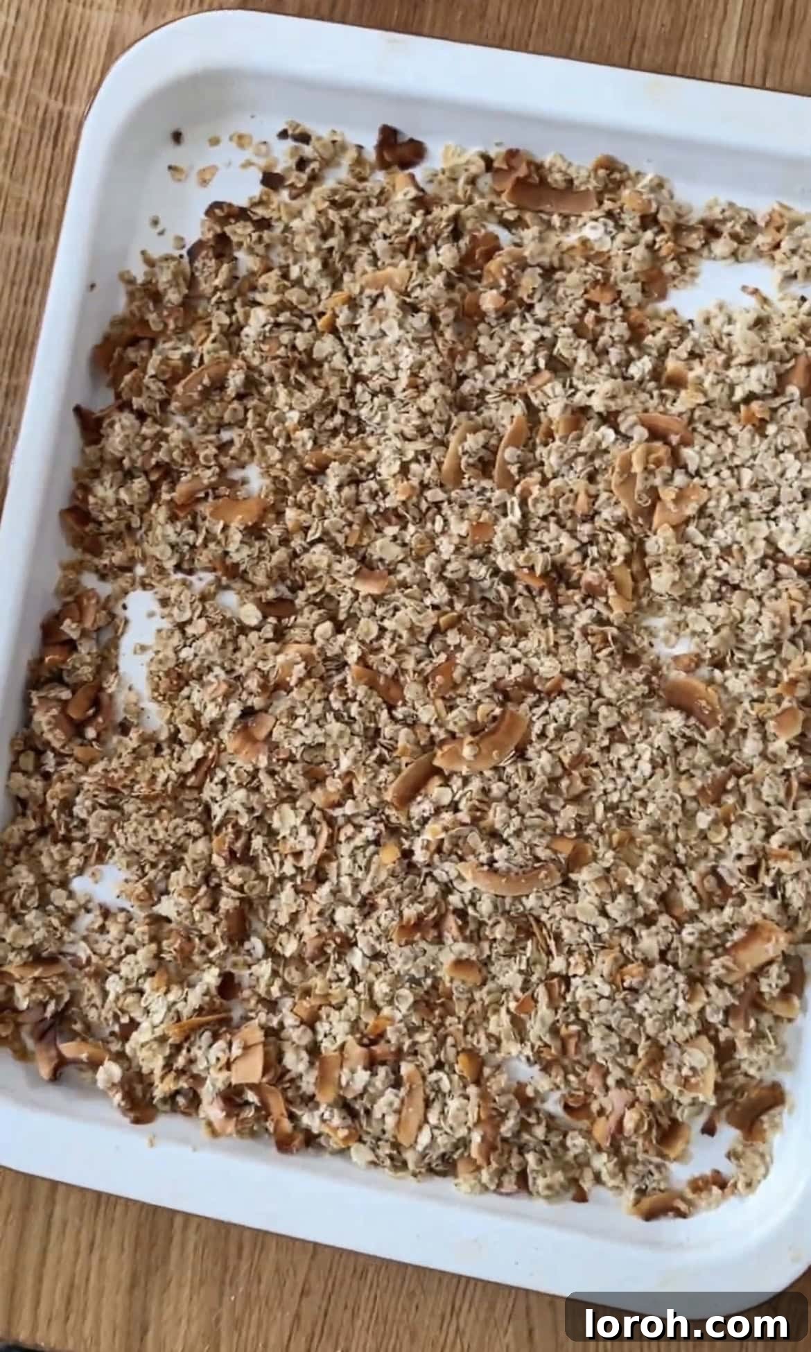 Toasted granola mixture spread on a baking tray.