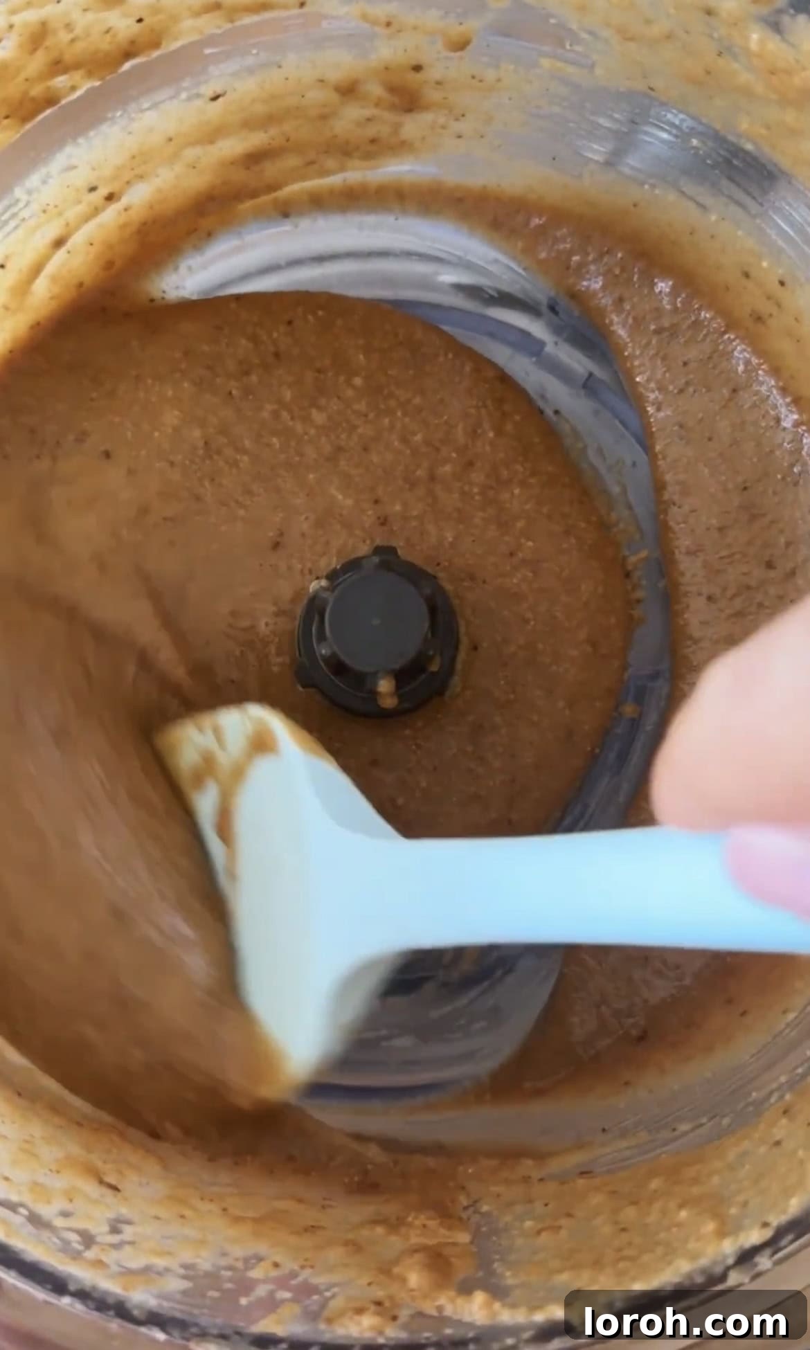 Smooth, blended granola butter inside a food processor.