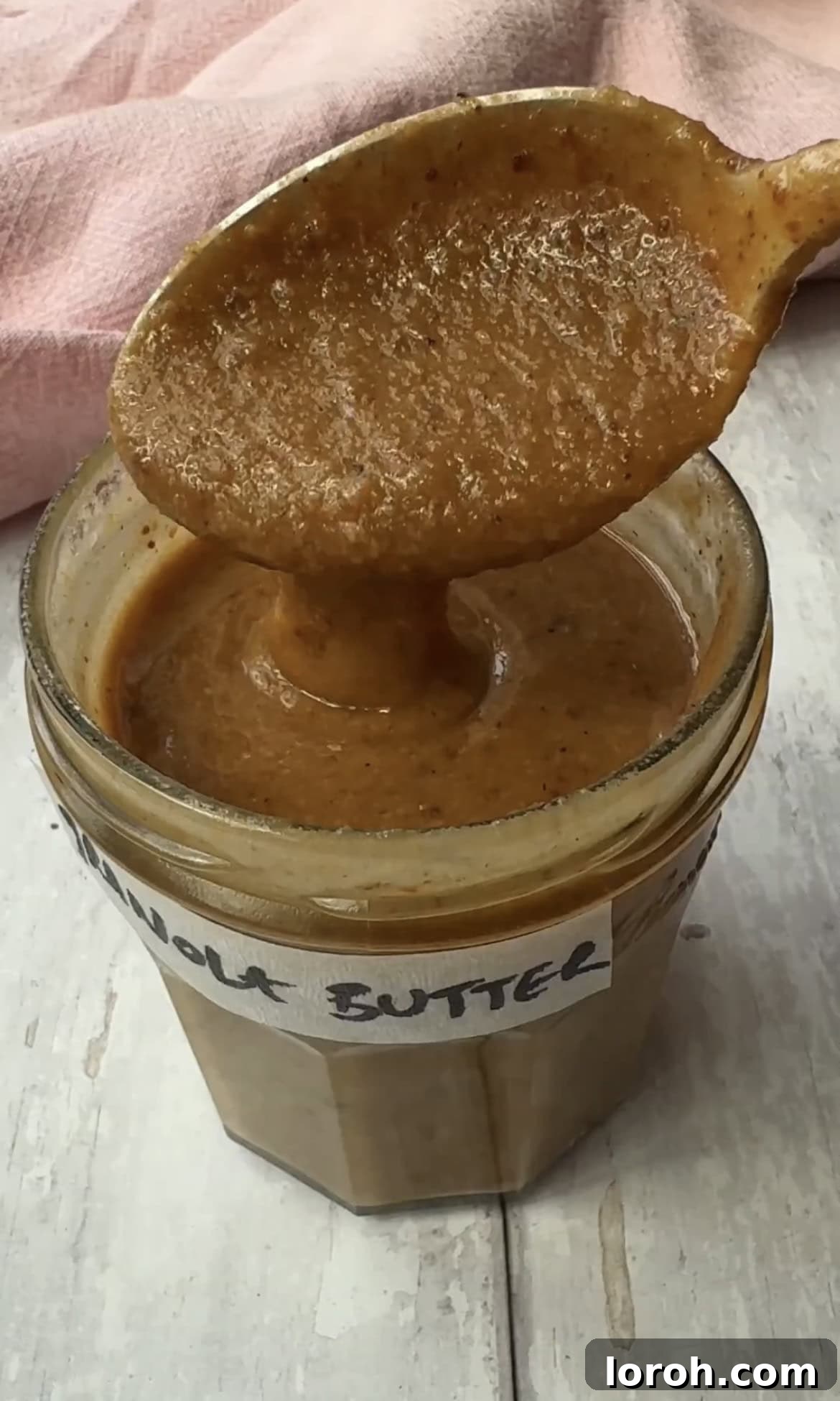 Freshly made granola butter in a glass jar.