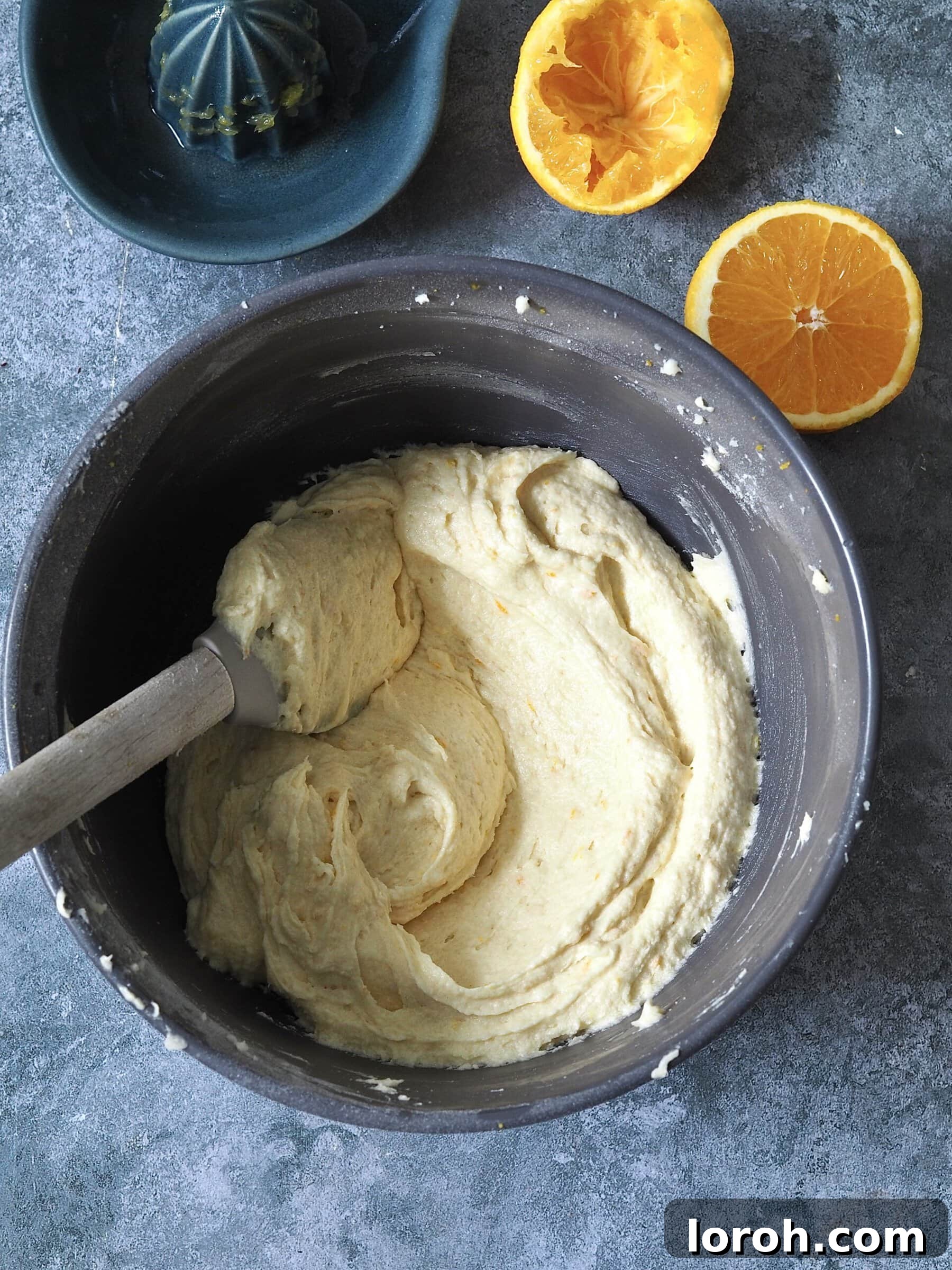 Smooth cake batter being mixed in a bowl with an electric whisk, showing consistency after eggs, flour, and baking powder are added.
