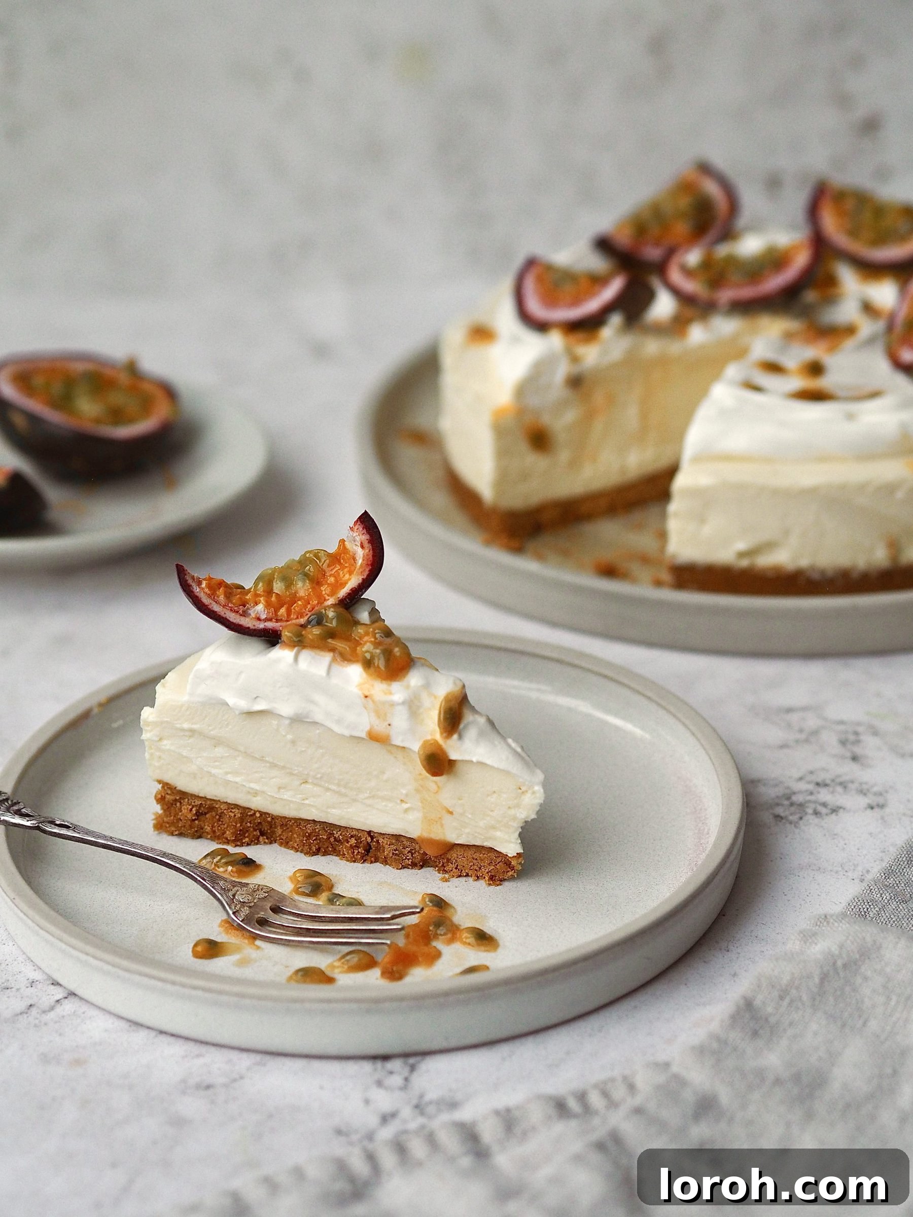 A slice of creamy White Chocolate and Passion Fruit Cheesecake on a white plate, showcasing its beautiful layers and vibrant topping.