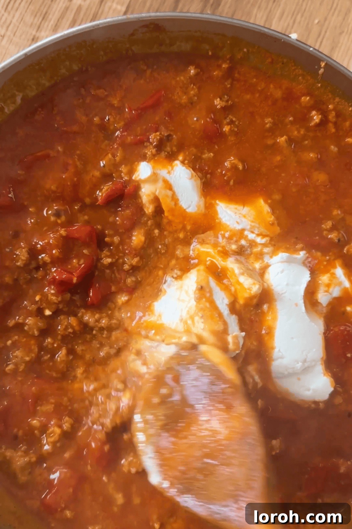 Mascarpone cheese being stirred into the simmering tomato and Nduja sauce.