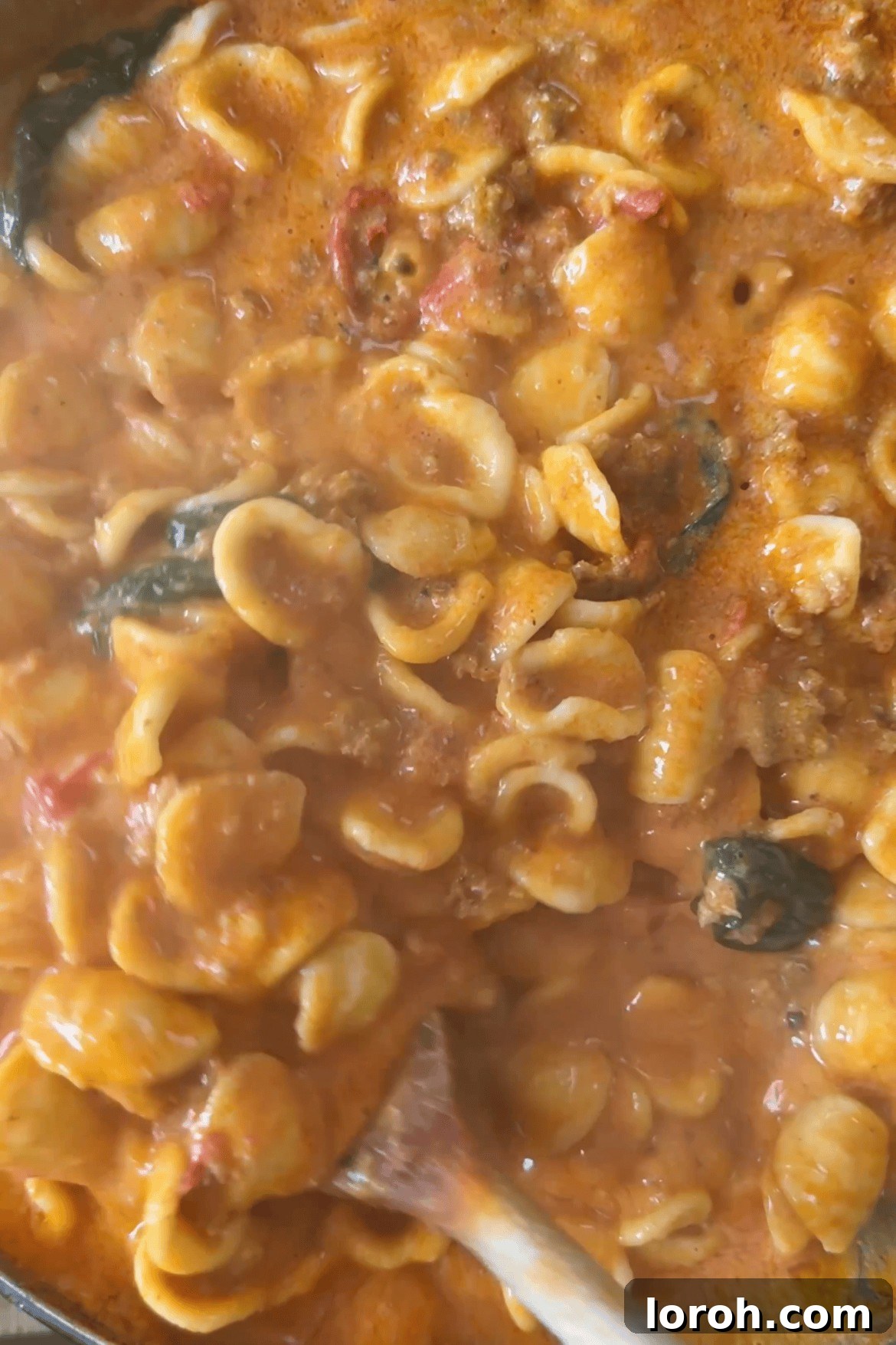 Drained orecchiette pasta being added to the pan with the creamy sausage Nduja sauce.