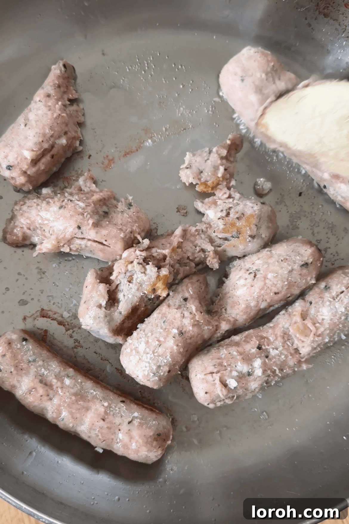 Frying sausages, broken into small pieces, until golden brown in a pan.