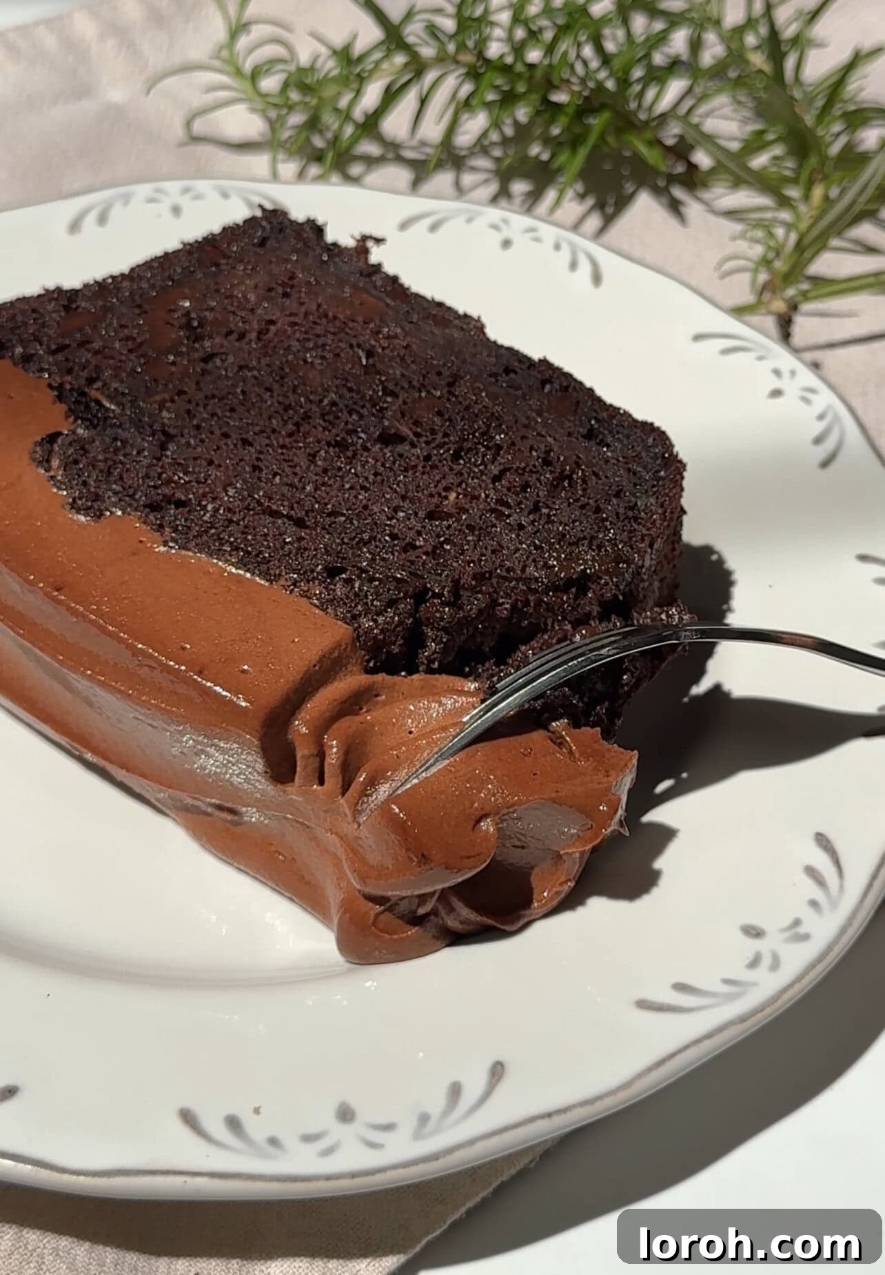 Fudgy Chocolate Zucchini Cake 3 A perfectly sliced piece of chocolate courgette cake on a plate, showcasing its moist interior.