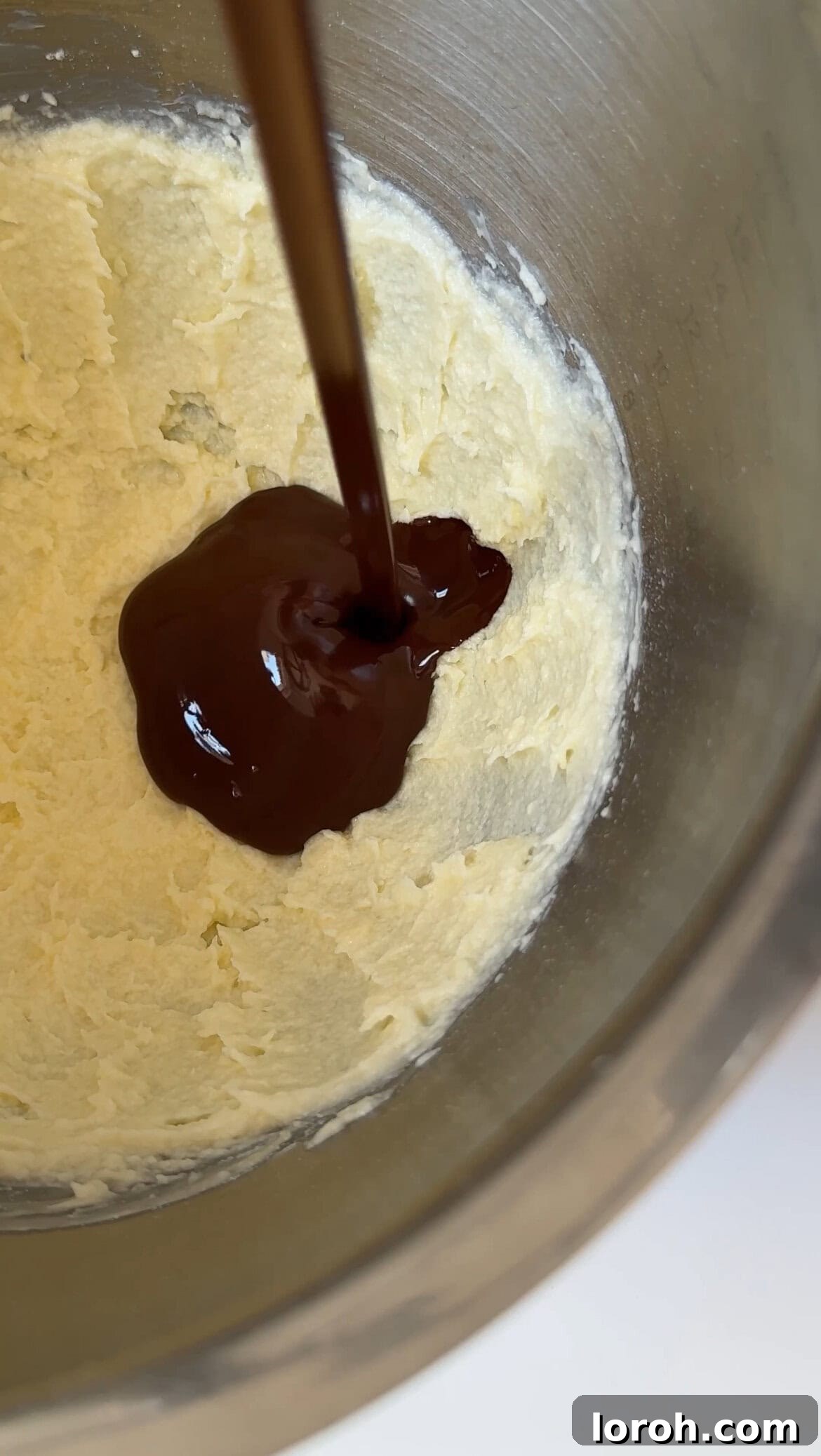 Fudgy Chocolate Zucchini Cake 9 Pouring melted and cooled dark chocolate into a bowl of whipped butter and sour cream for frosting.