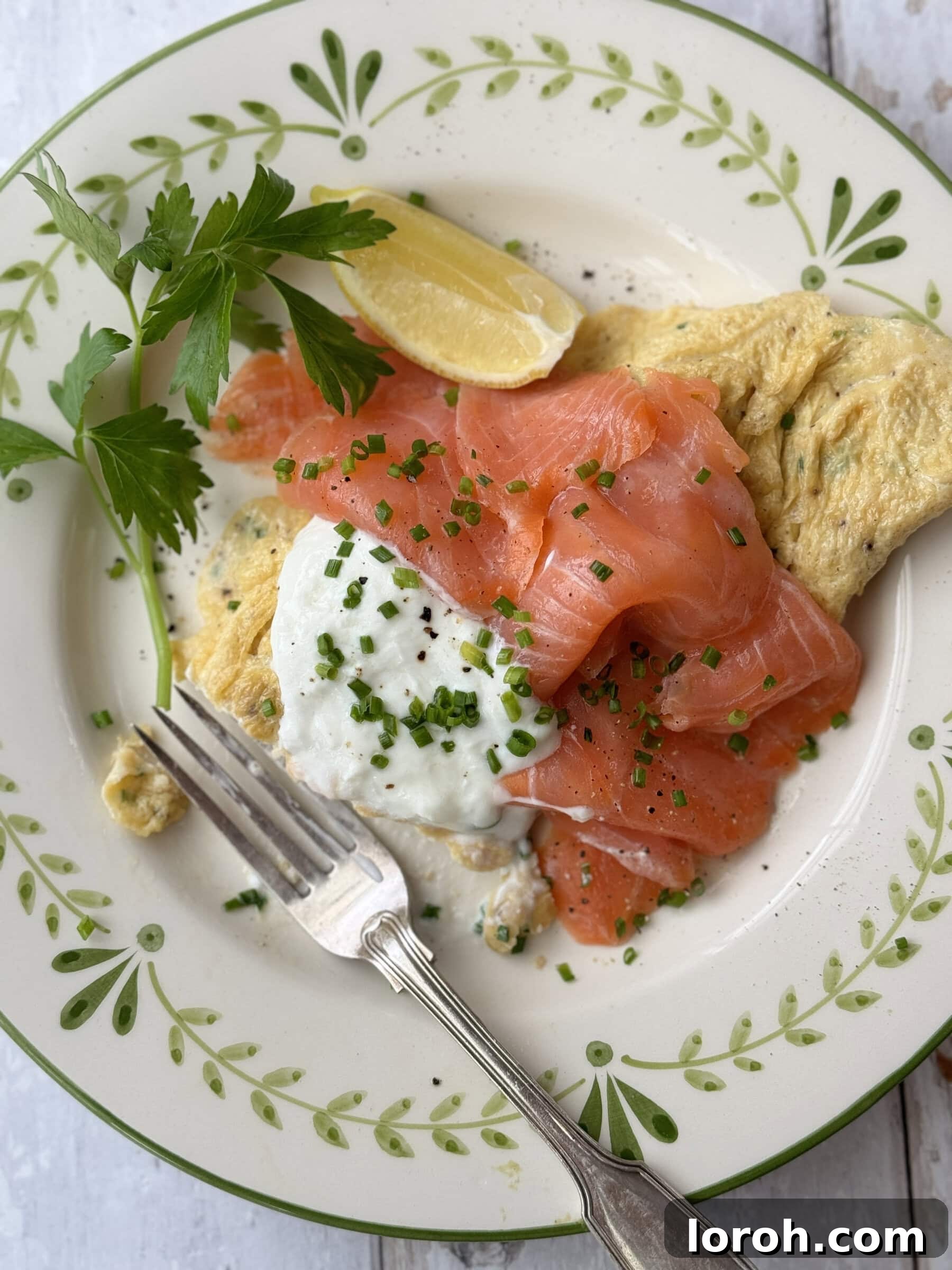 Exquisitely presented smoked salmon omelette on a pristine white plate, garnished with fresh herbs.