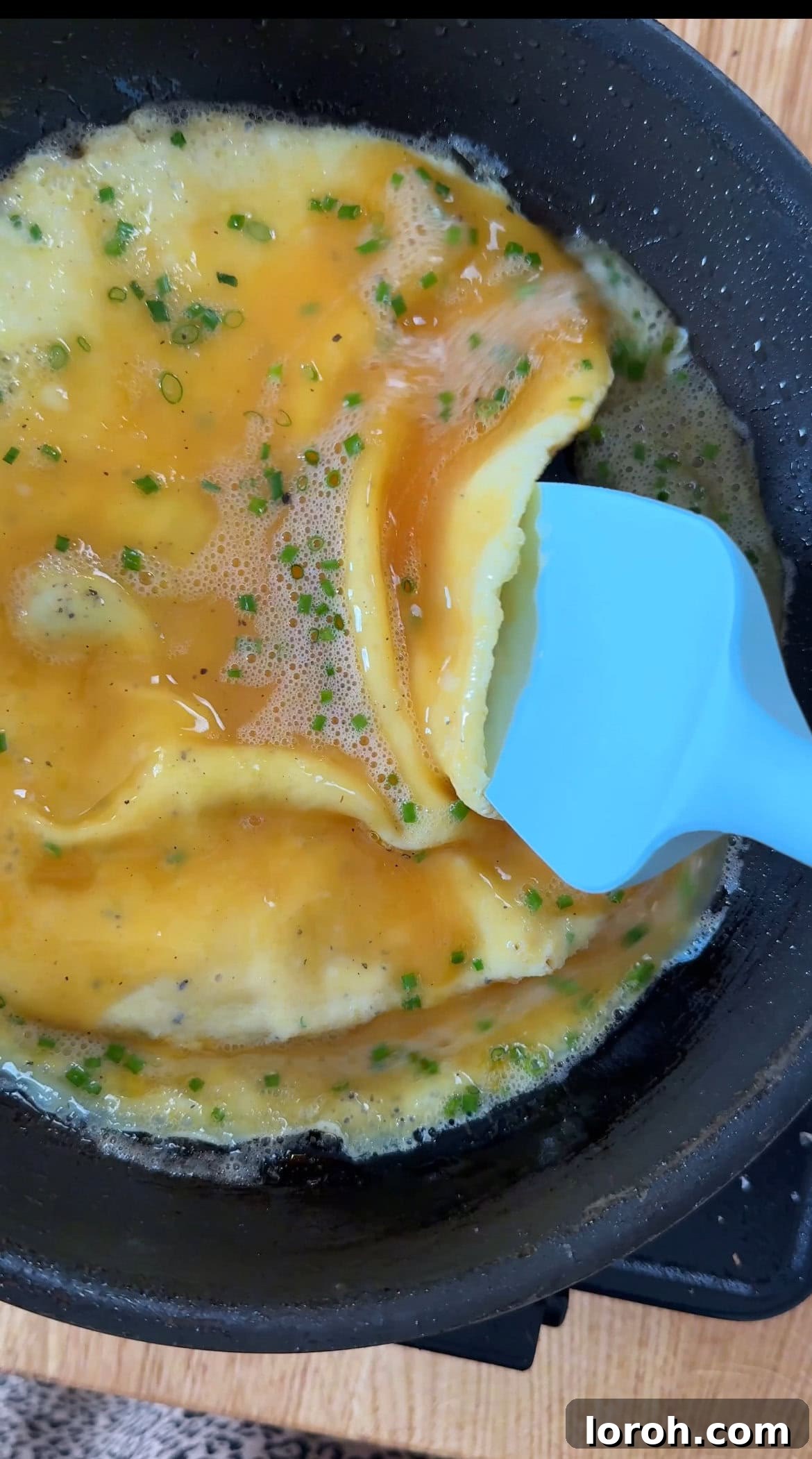 Step four: Using a spatula to gently push cooked eggs towards the center.