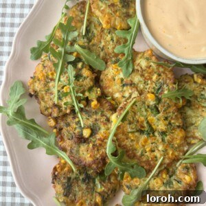 A perfectly cooked courgette corn fritter on a plate