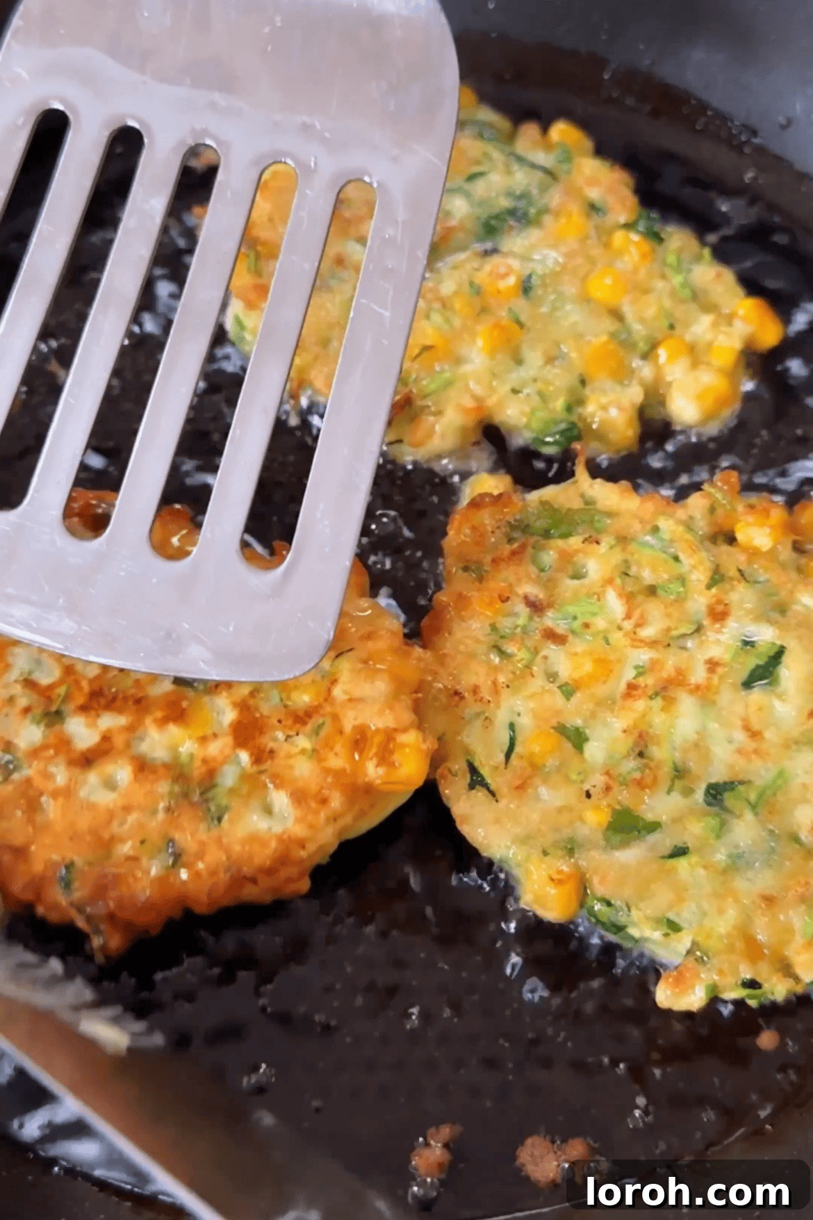 Golden-brown fritters being flipped in a pan