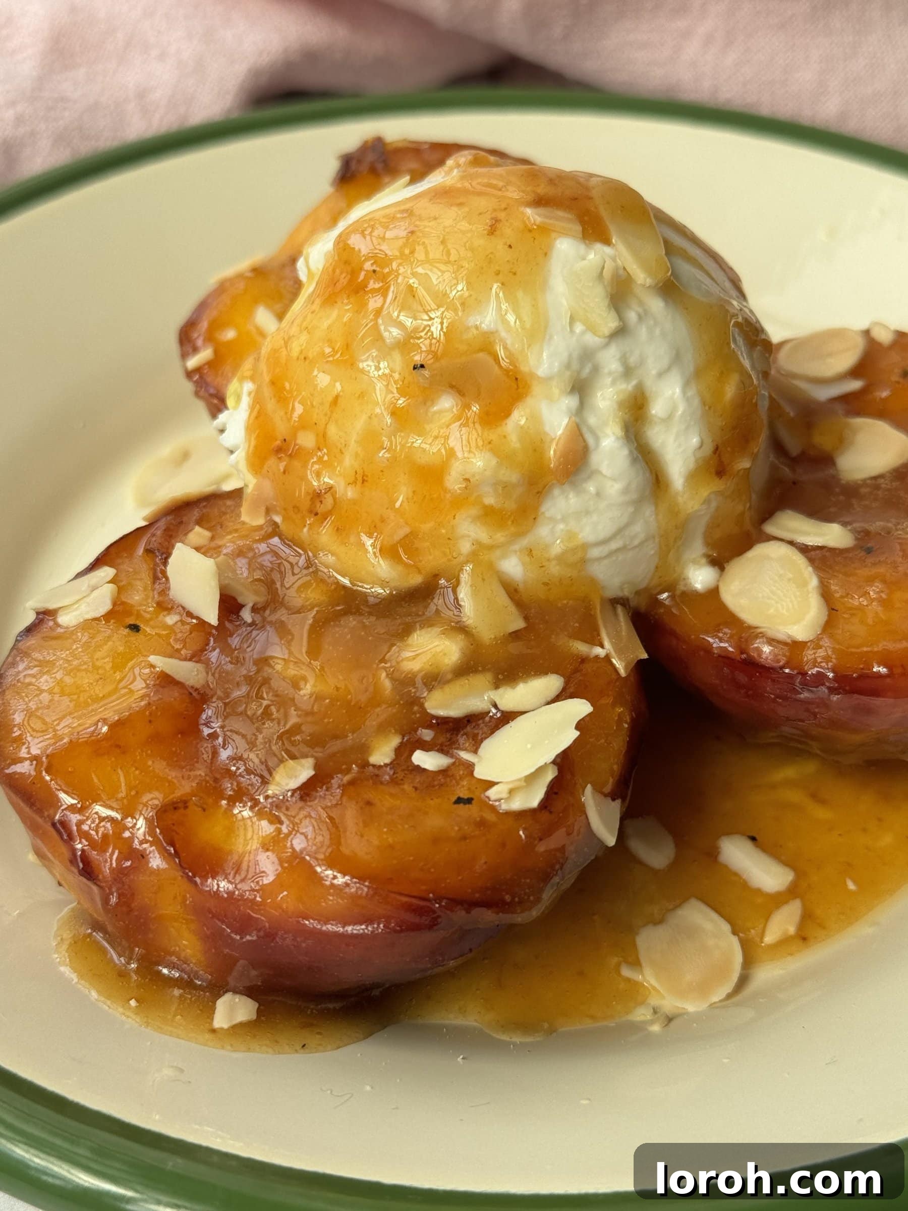 Another view of peaches and cream on a white plate with a green rim, emphasizing the texture and presentation.