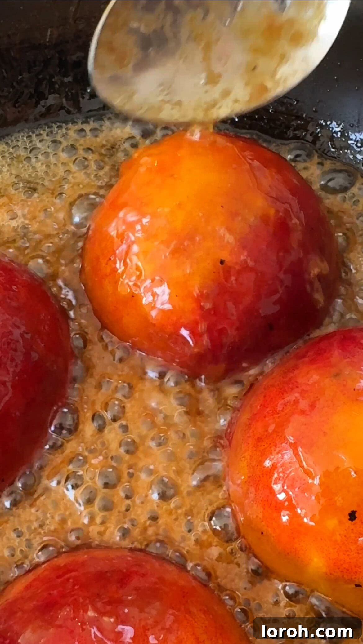 Basting peaches with the brown butter caramel during cooking.