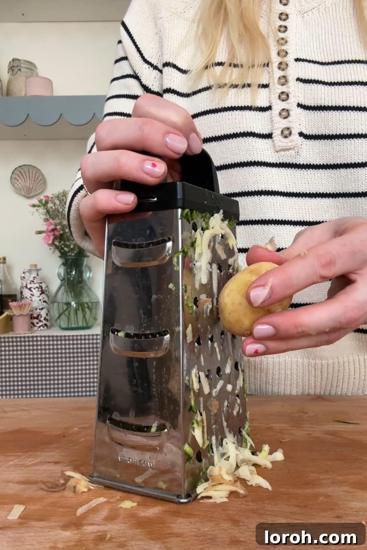 Rustic Italian Zucchini Tart 4 A hand grating a potato using a box grater, demonstrating the first step in preparing the Scarpaccia batter.